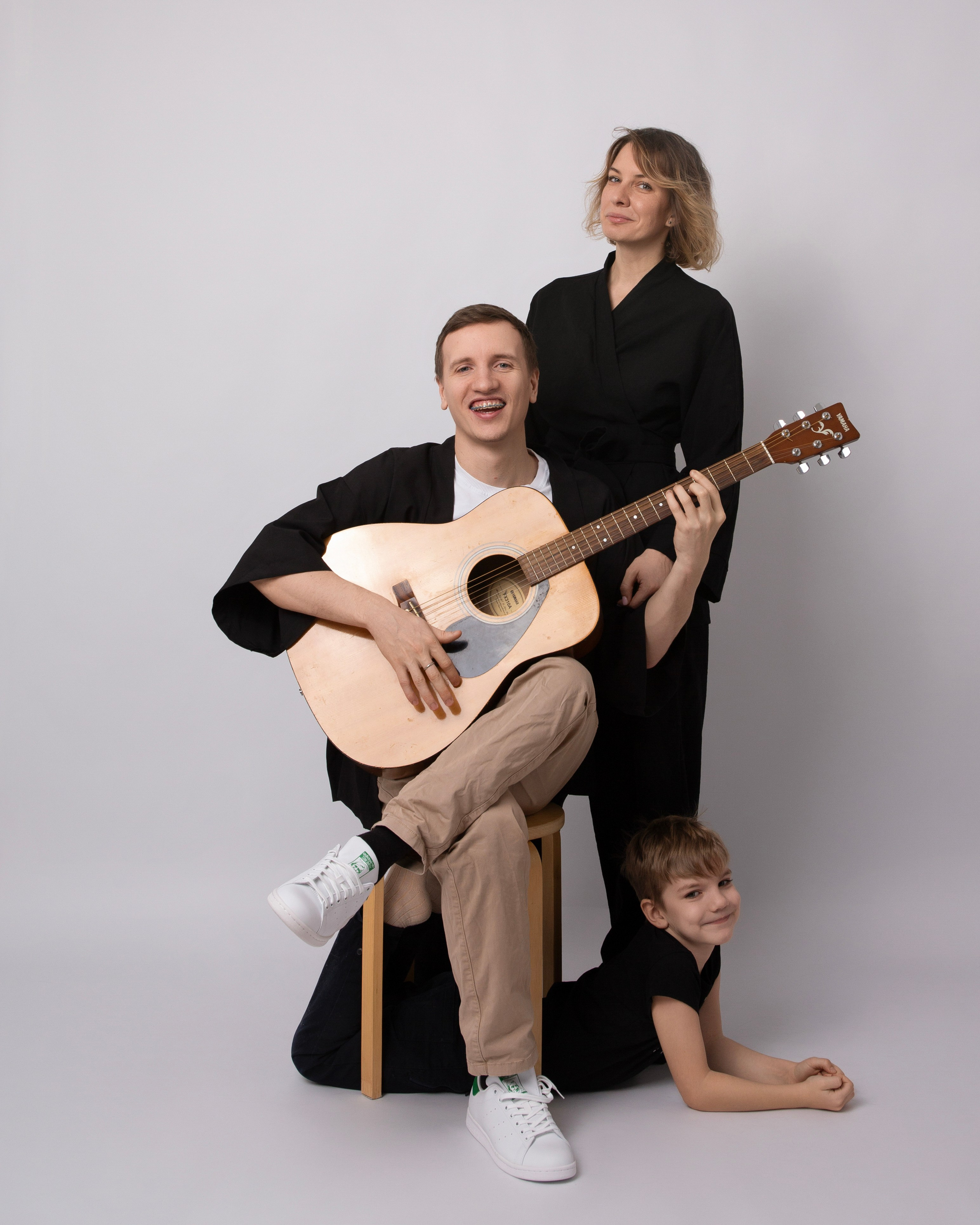 Семейная фотосессия с детьми, папа играет на гитаре, мама и сын.