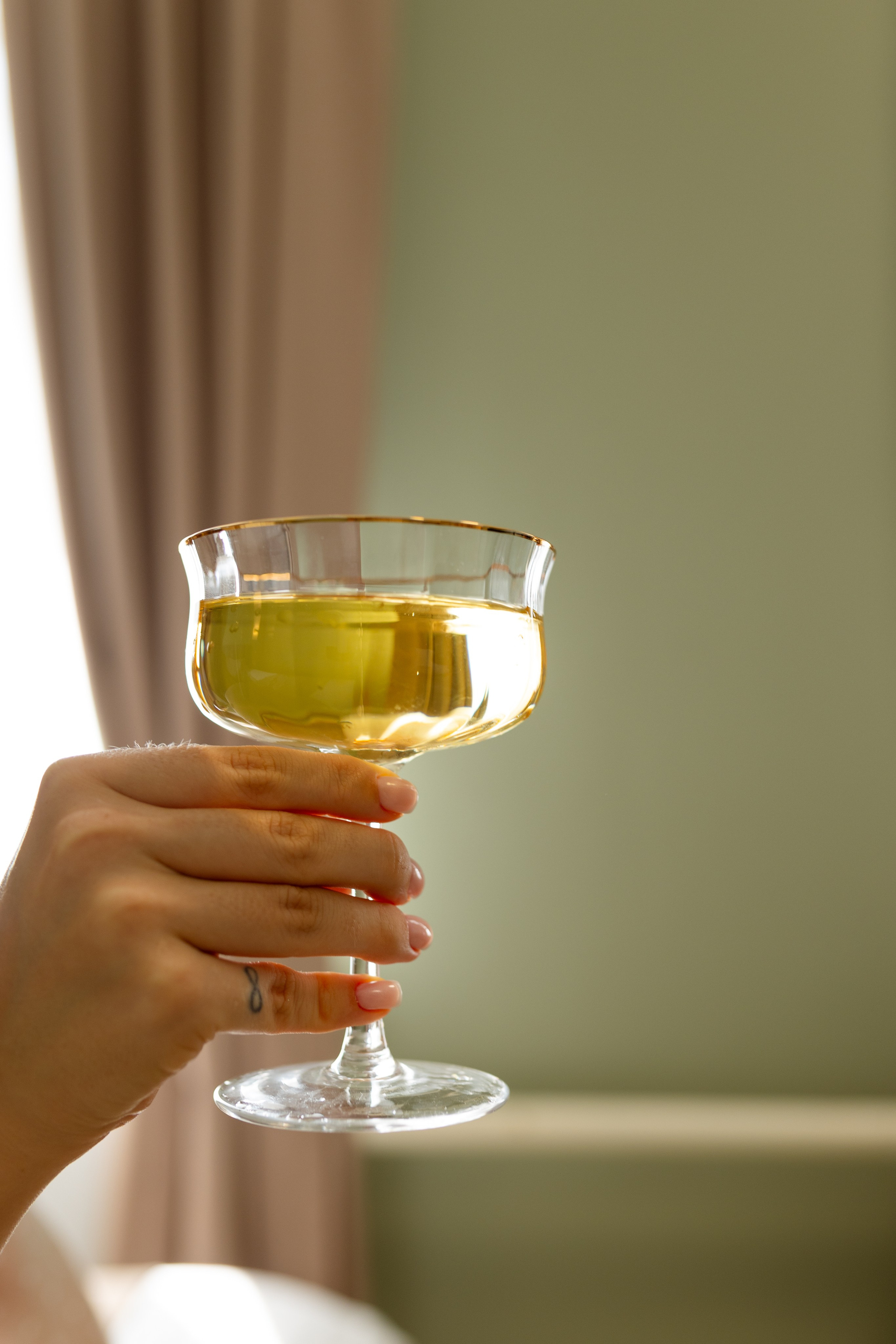 На фото крупным планом рука держит  бокал.