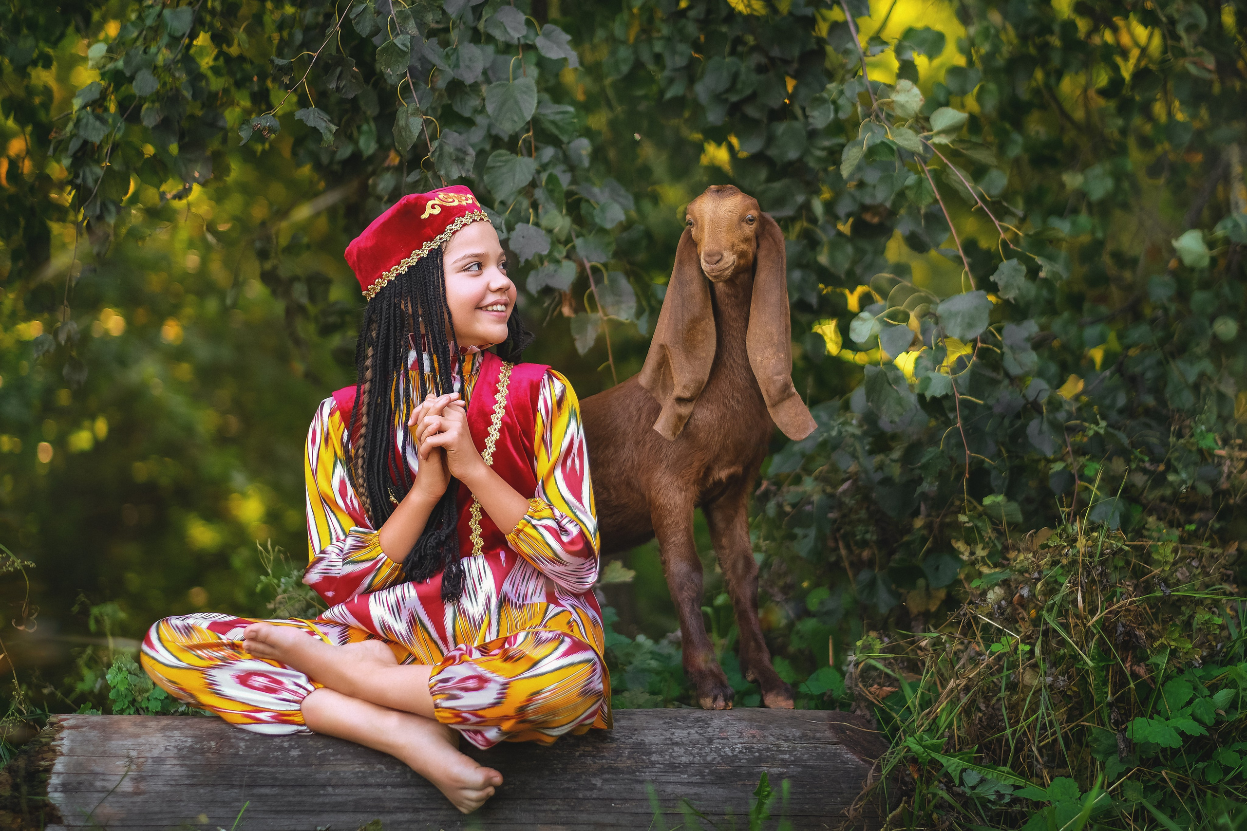 Милая девочка с козликом в национальном костюме