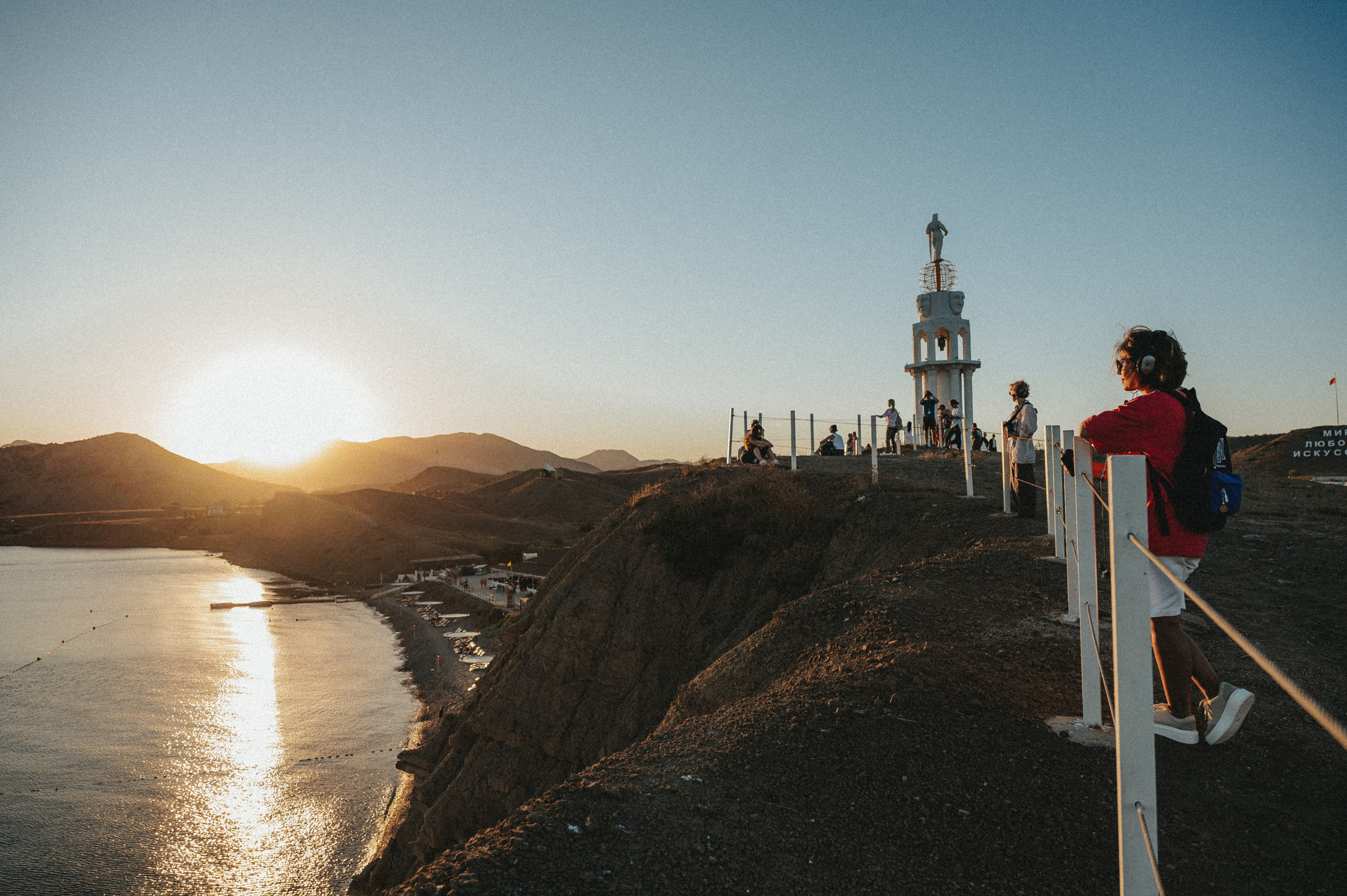 Репортажная съемка экскурсии с гостями на берегу моря на фоне заката