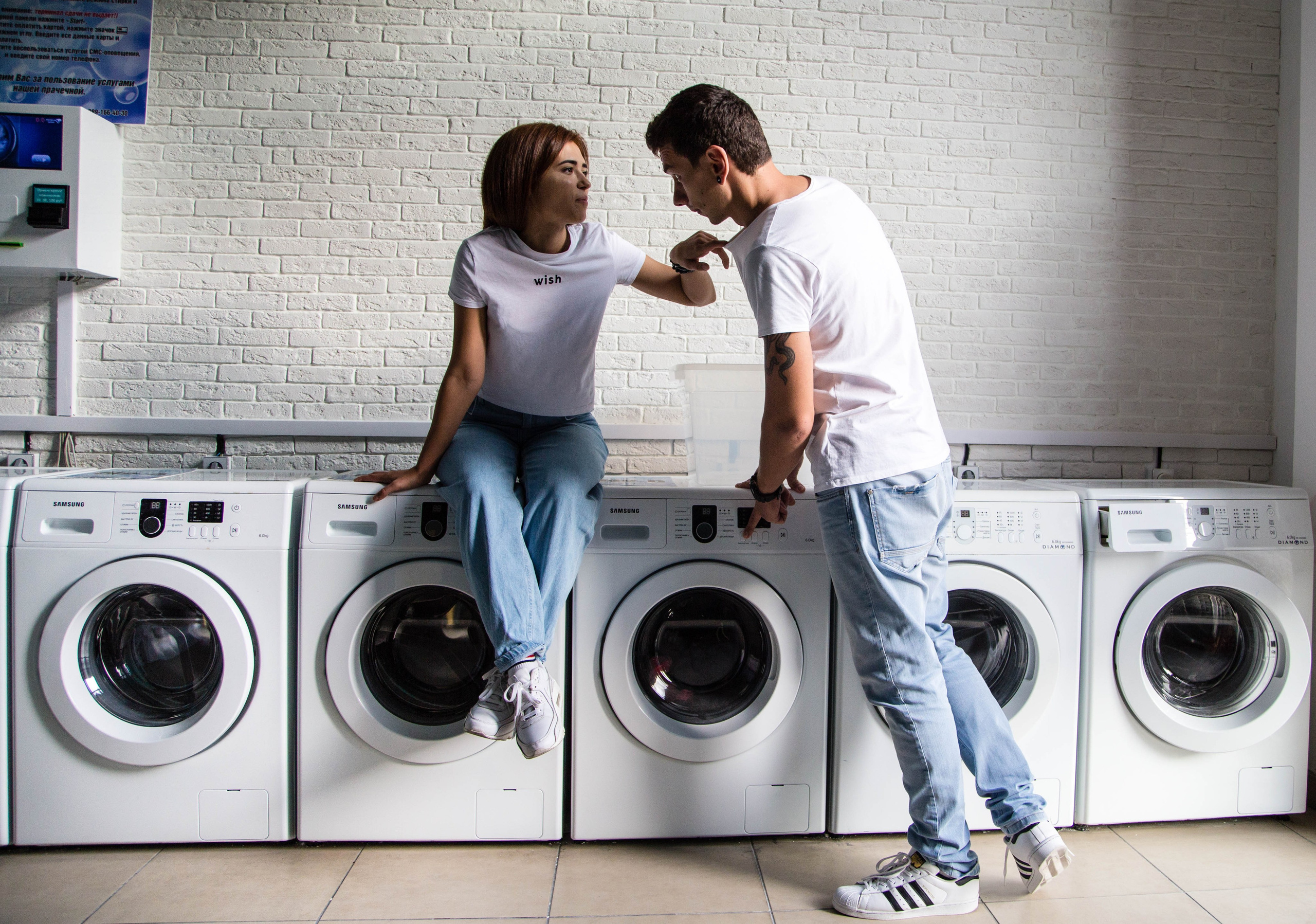 Снимок парня и девушки внутри прачечной 
