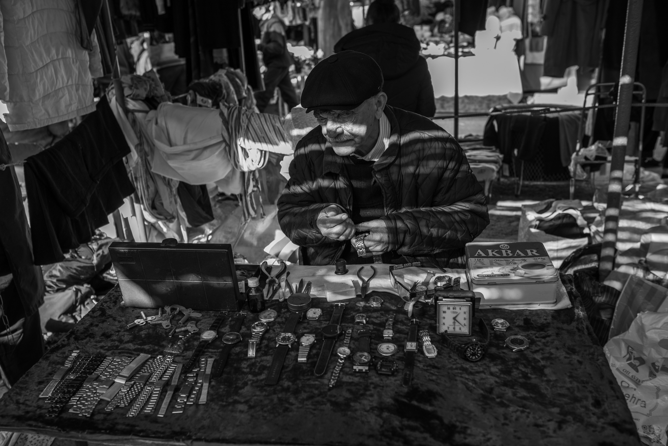 Мужчина мастер по ремонту часов на базаре Янгиабад, базар Янгиабад