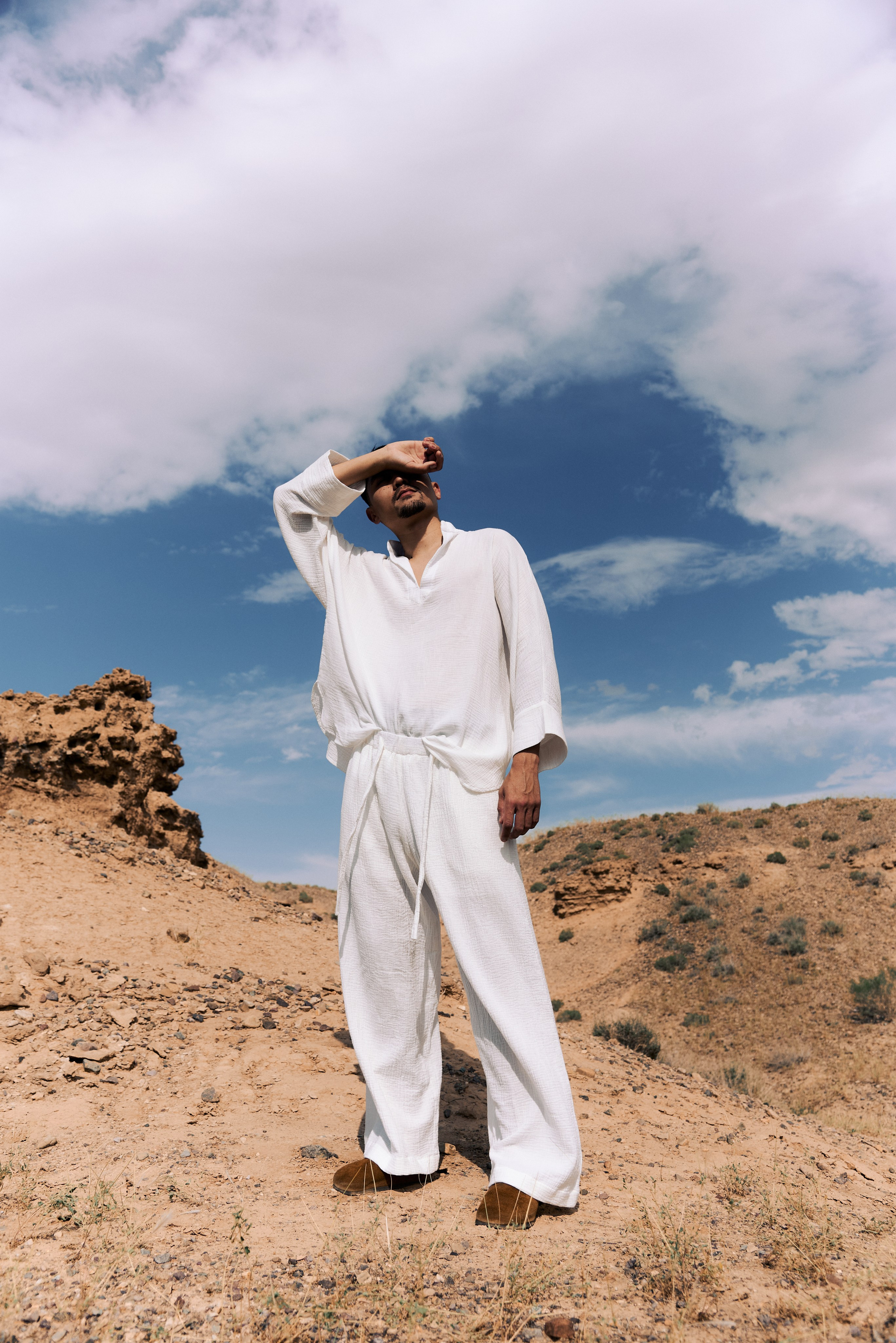мужчина в белом на фоне пустыни и голубого неба