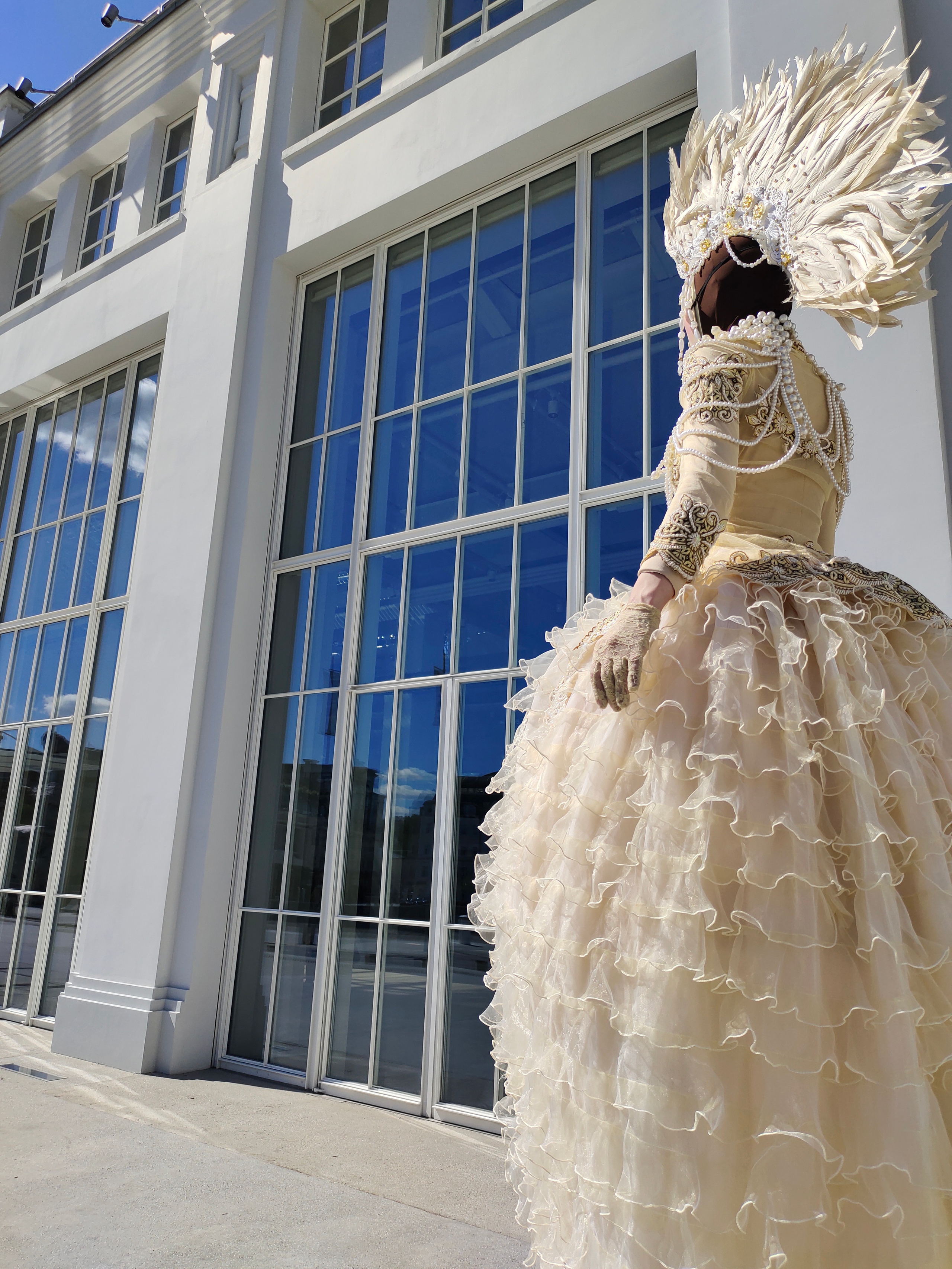 Ходулист повернулся спиной к фотографу и направляется к гостям вдоль ресторана.