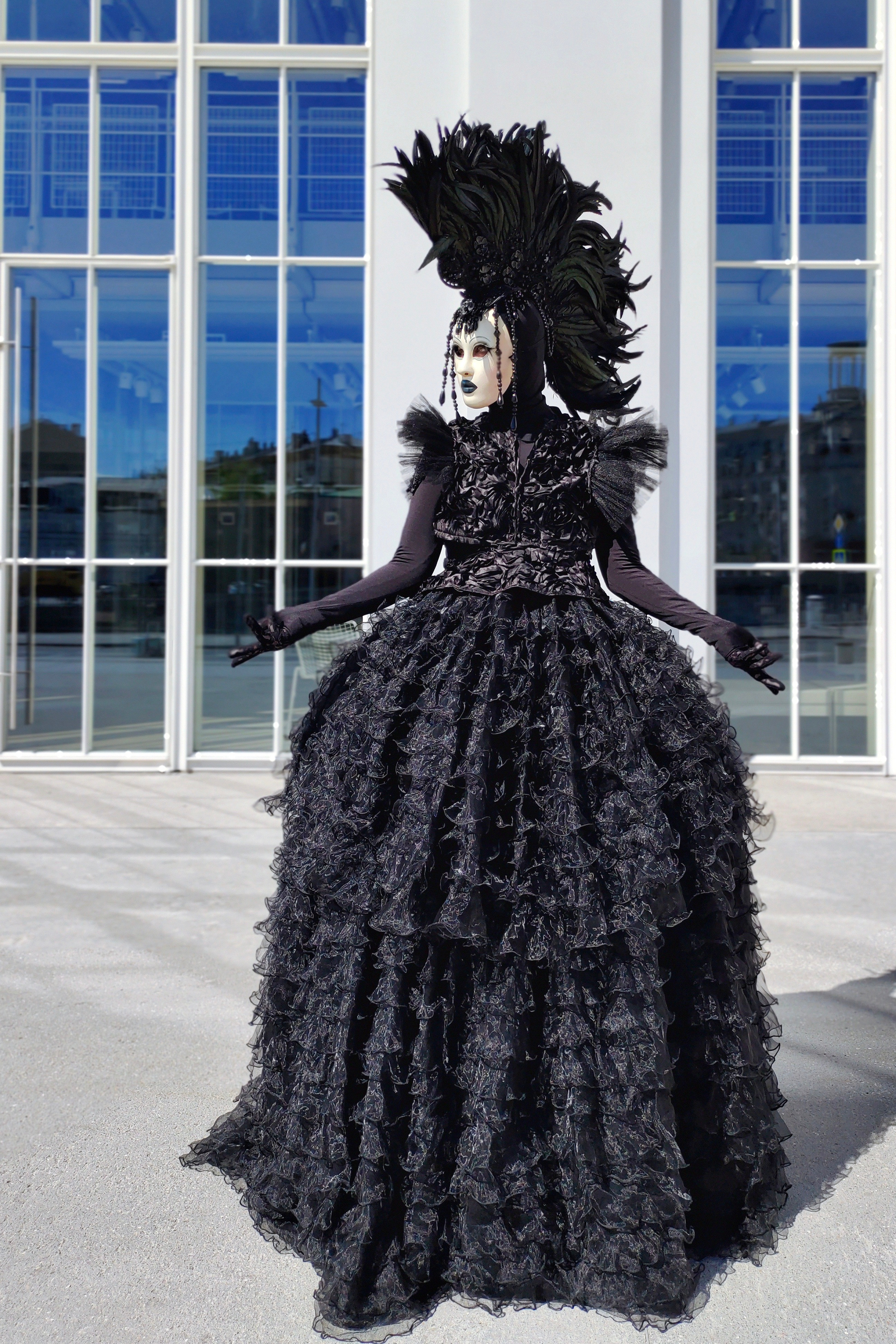 Артист в шикарном чёрном платье в маске и ирокезом на голове на вэлком-зоне.