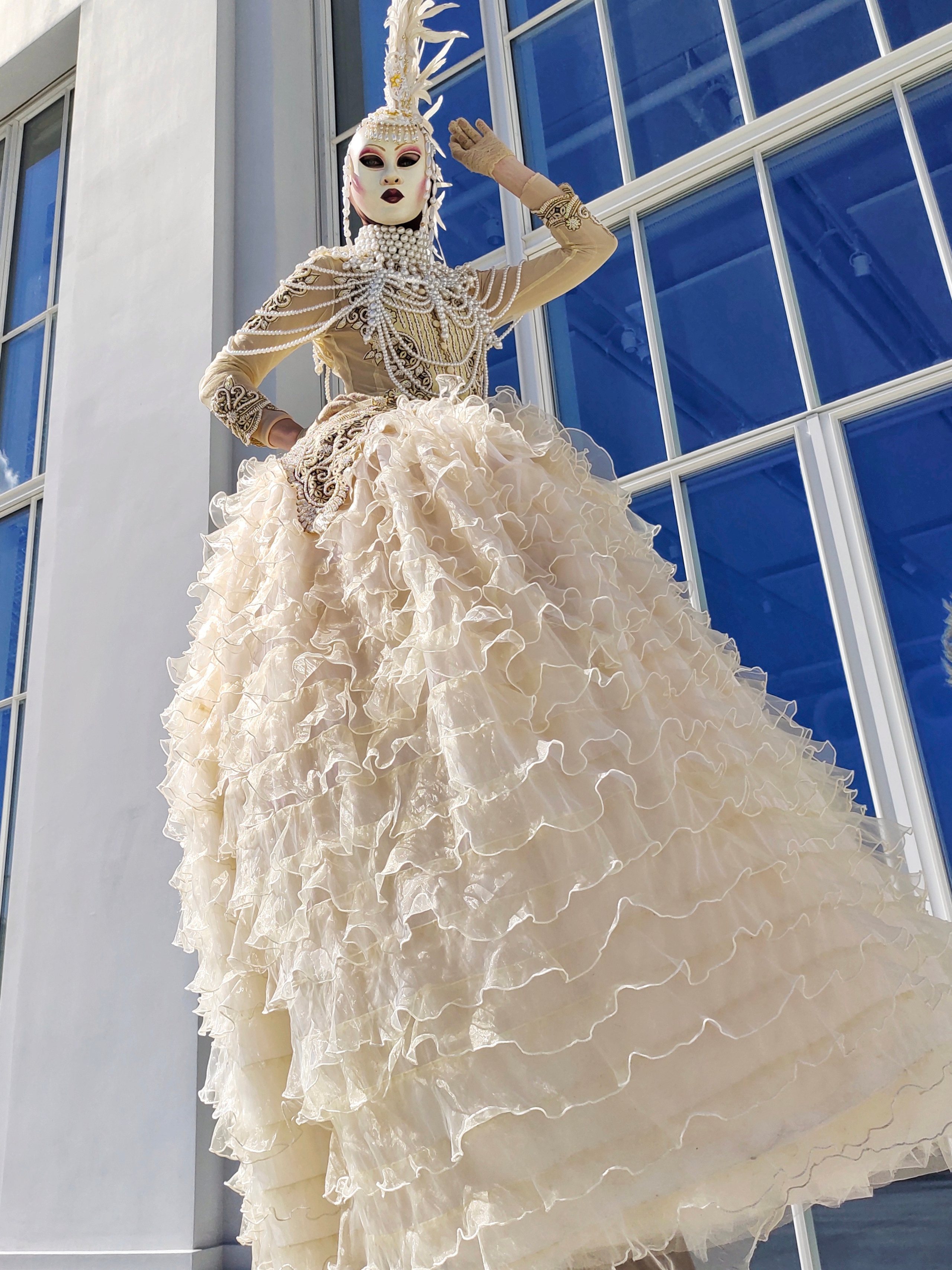 Широкое светлое платье на артисте ходулисте во время встречи гостей в Москве.