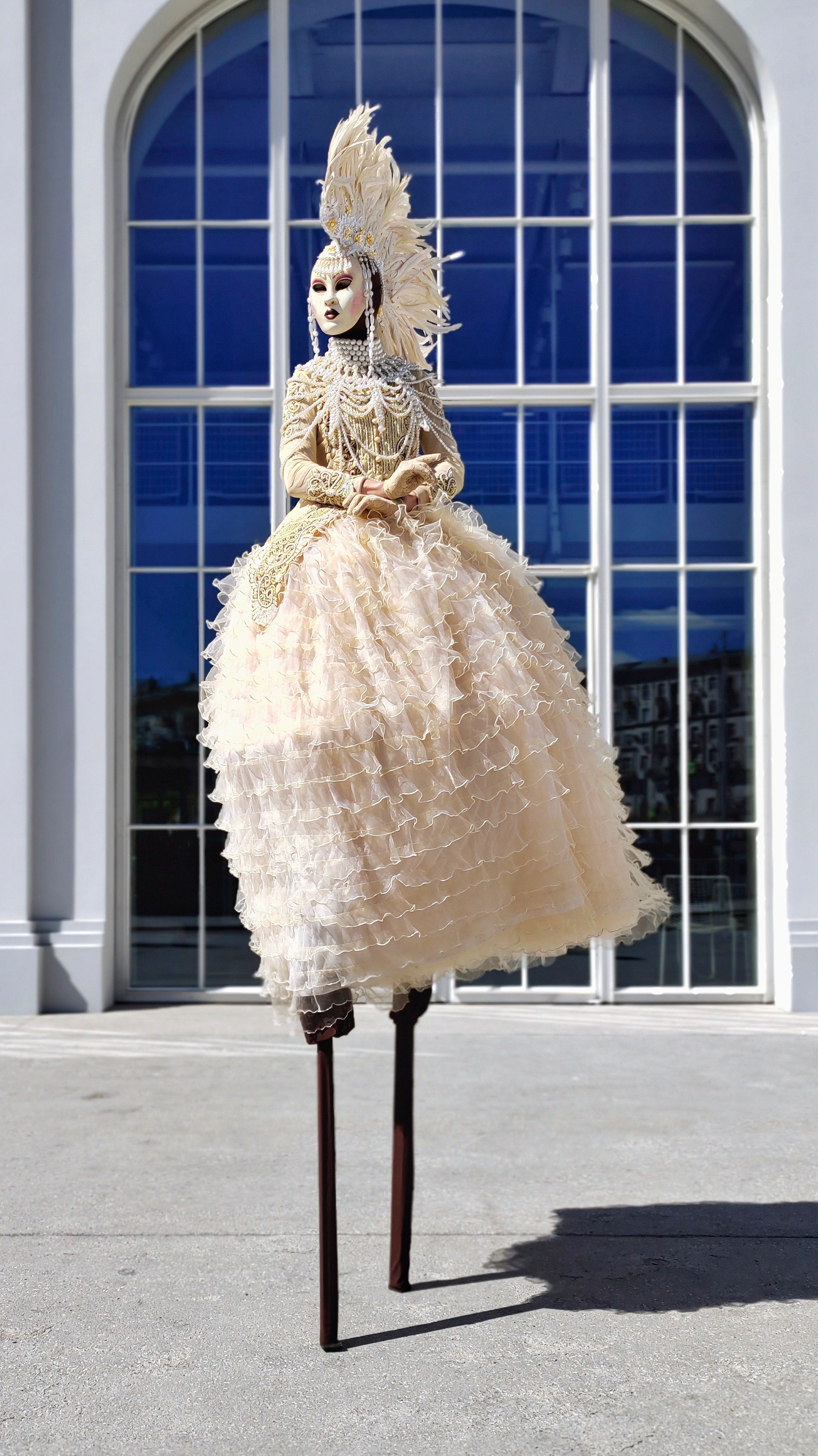 Велком зона на мероприятии с ходулистом в маске и светлом ирокезе на голове.