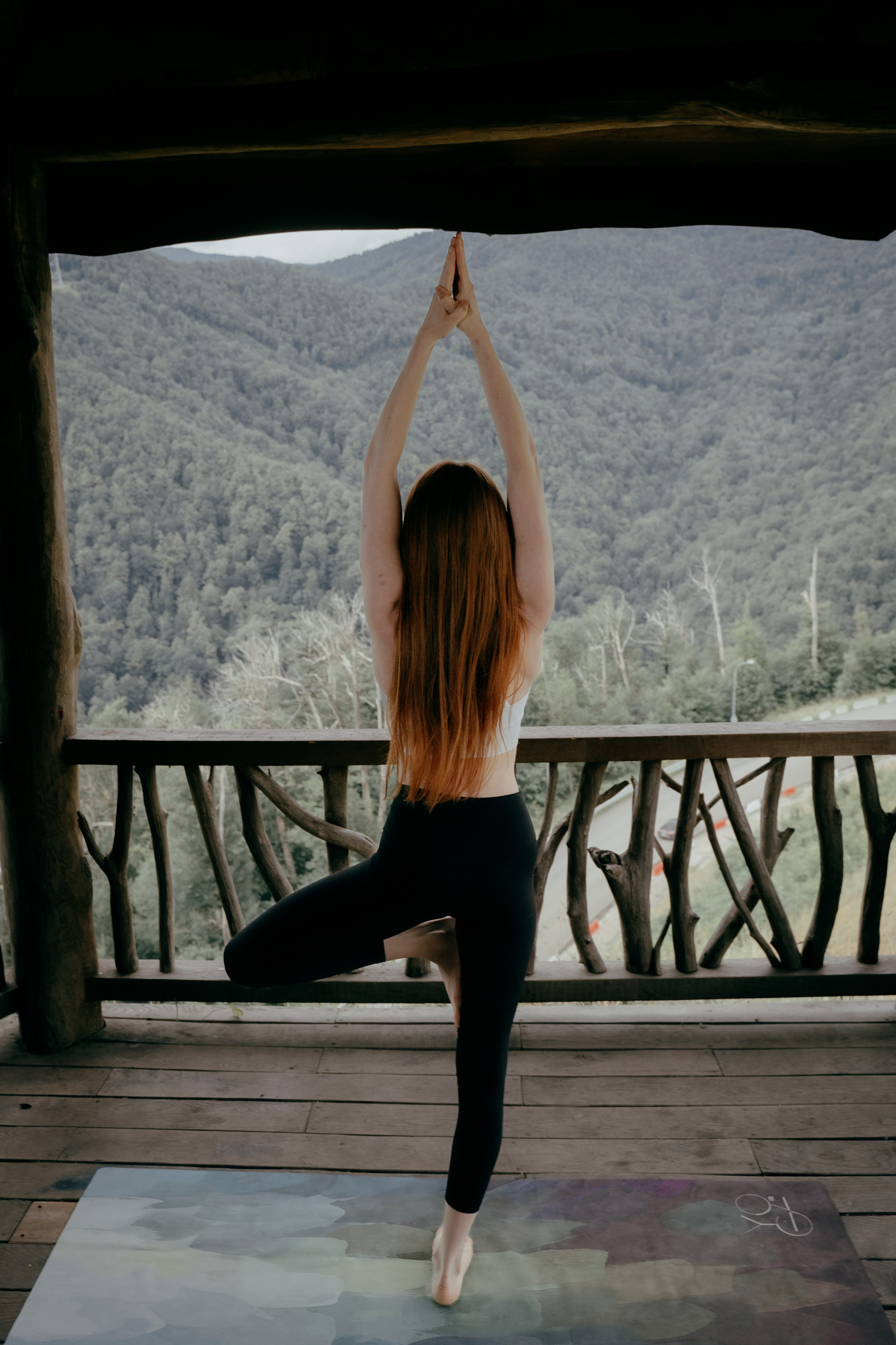 Фотоснимок девушки стоящей на одной ноге со спины