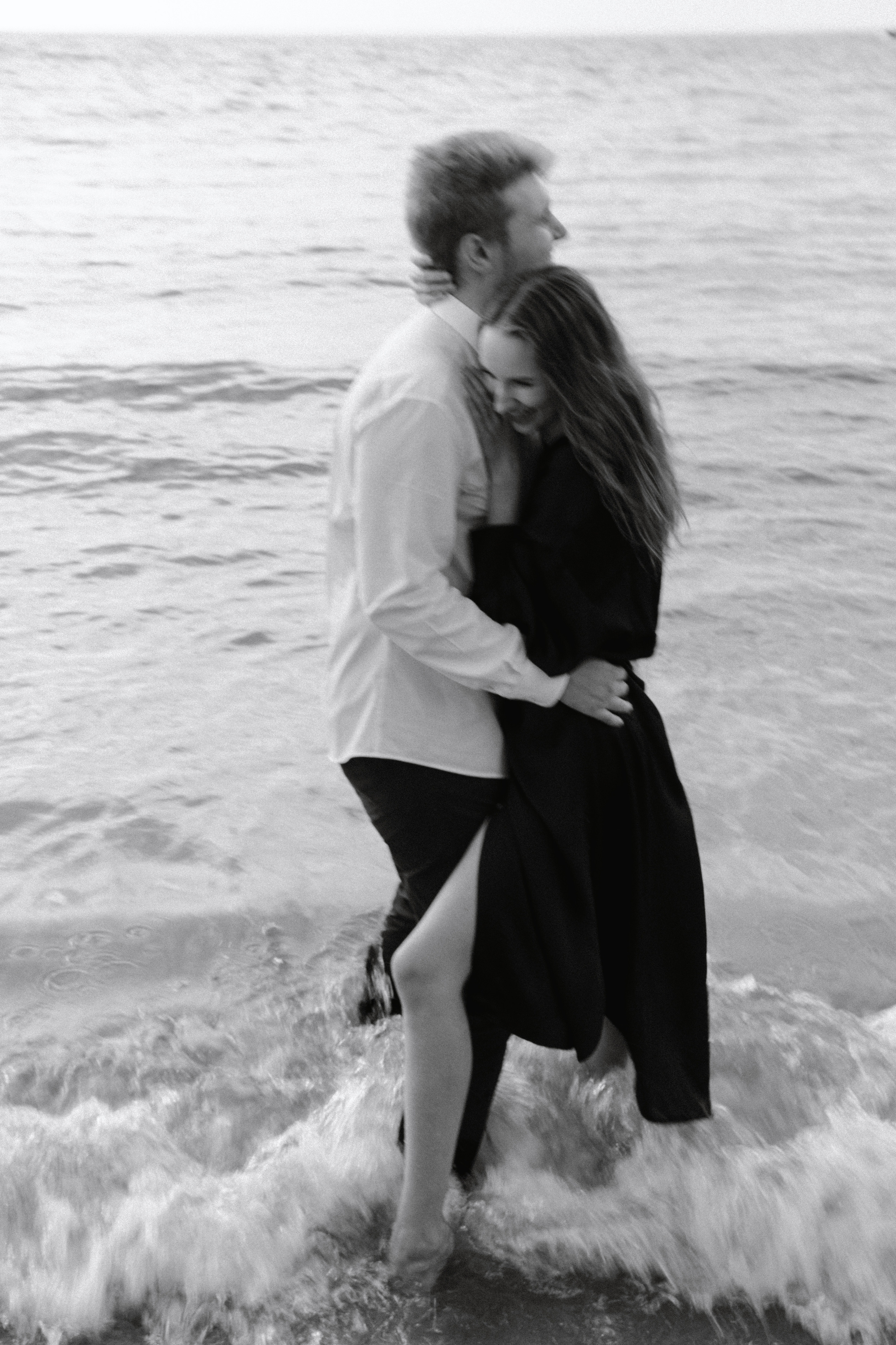 Пара обнимается в воде и смеется