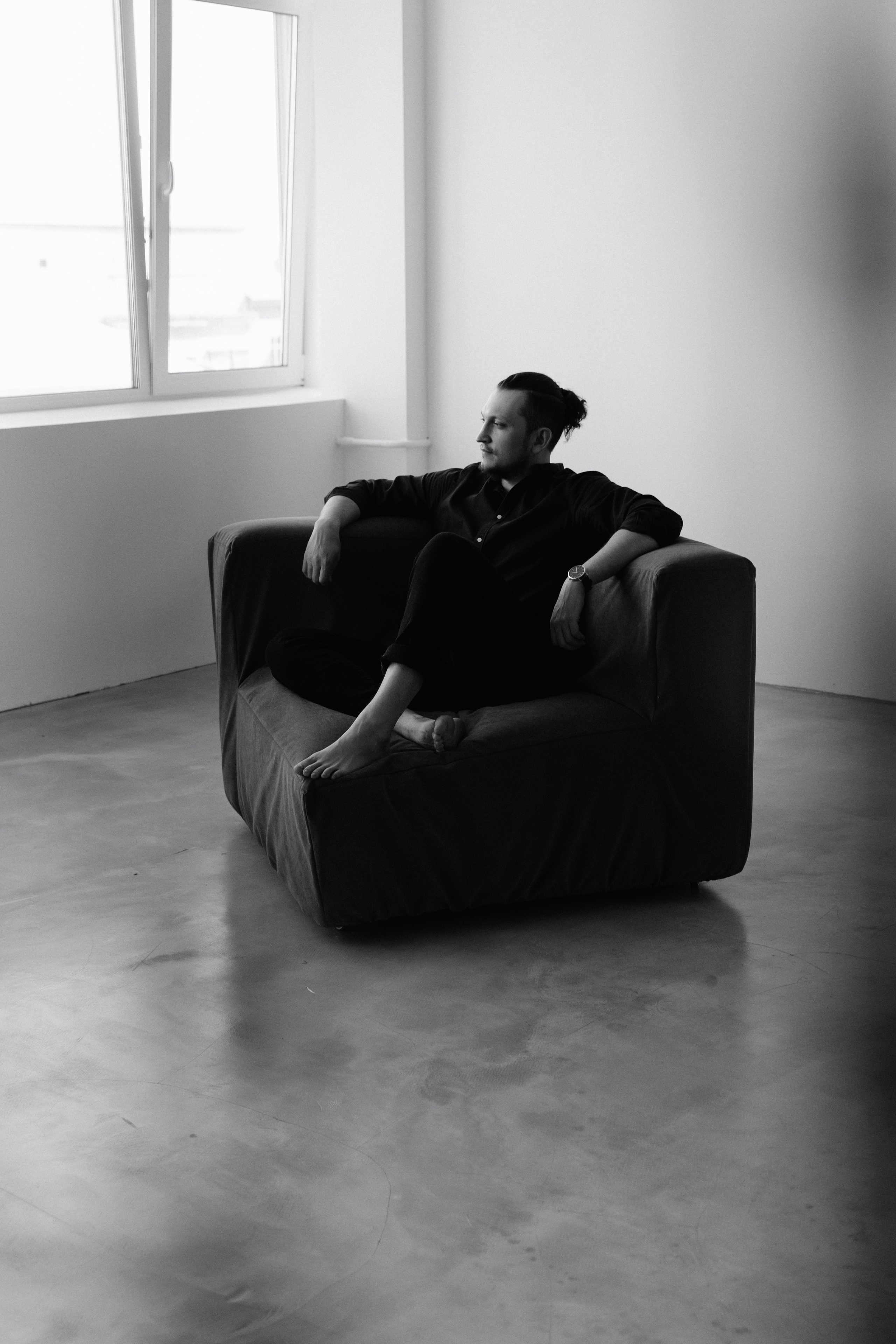 Черное белое фото мужчины в кресле в фотостудии