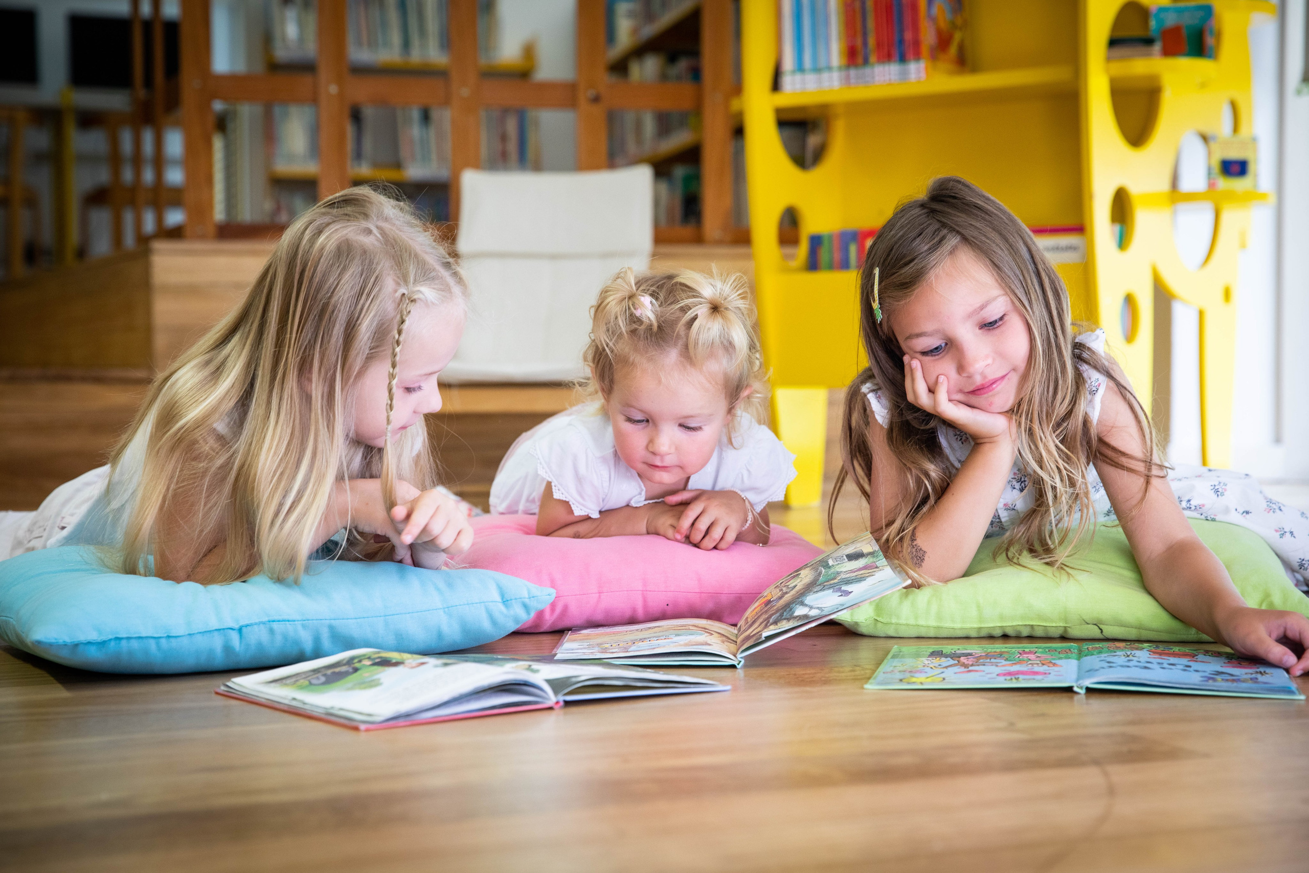 A little girl with a big smile, lost in the pages of an exciting book
