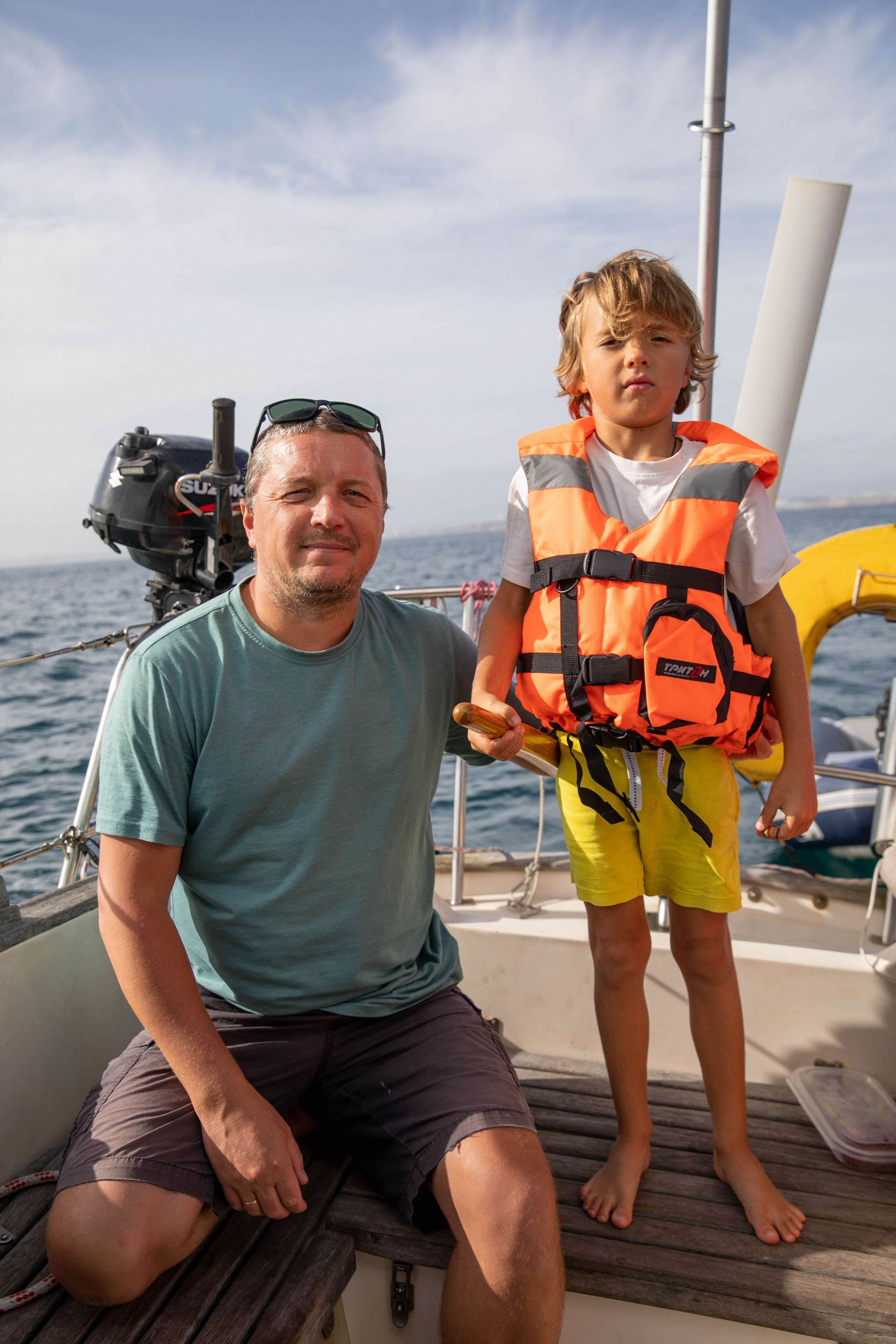 Families with children are photographed during a sailing yacht trip in the Algarve. Boys in lifejackets steer a sailing yacht and watch birds and dolphins through binoculars.  Photographer in Portugal. Oksana Lomnova