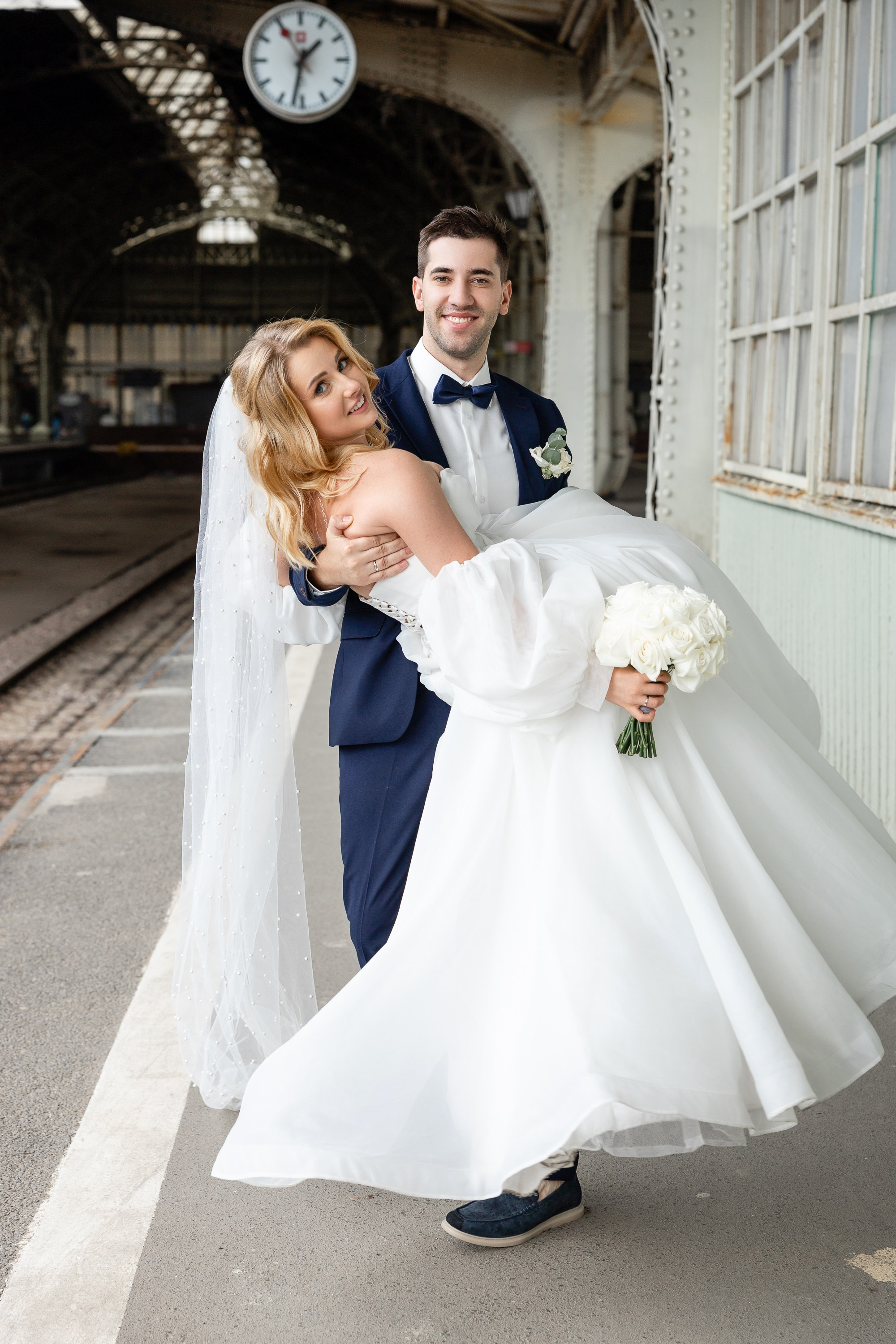Жених кружит на руках невесту на перроне Витебского вокзала