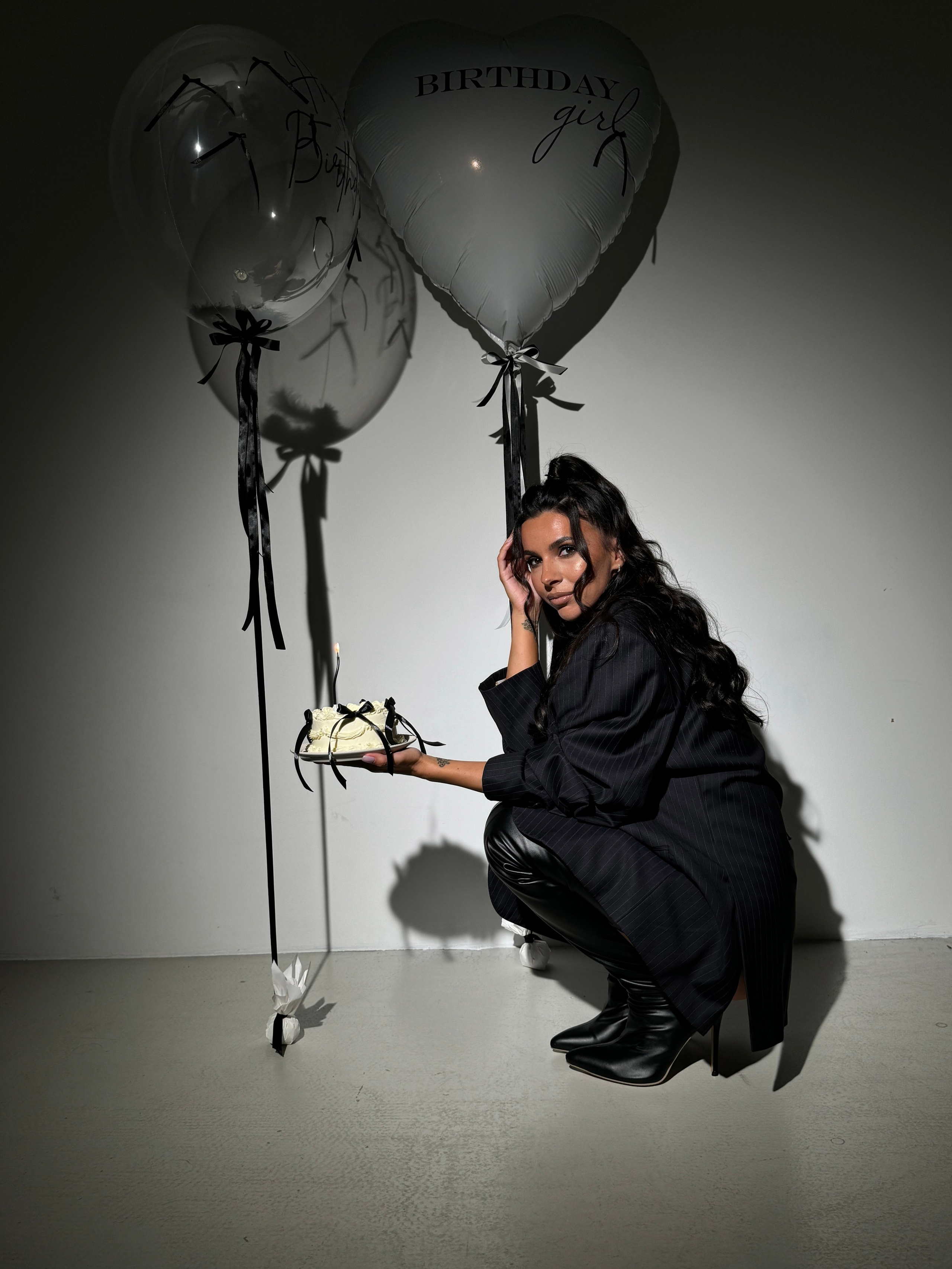 Девушка позирует с воздушными шарами и тортиком