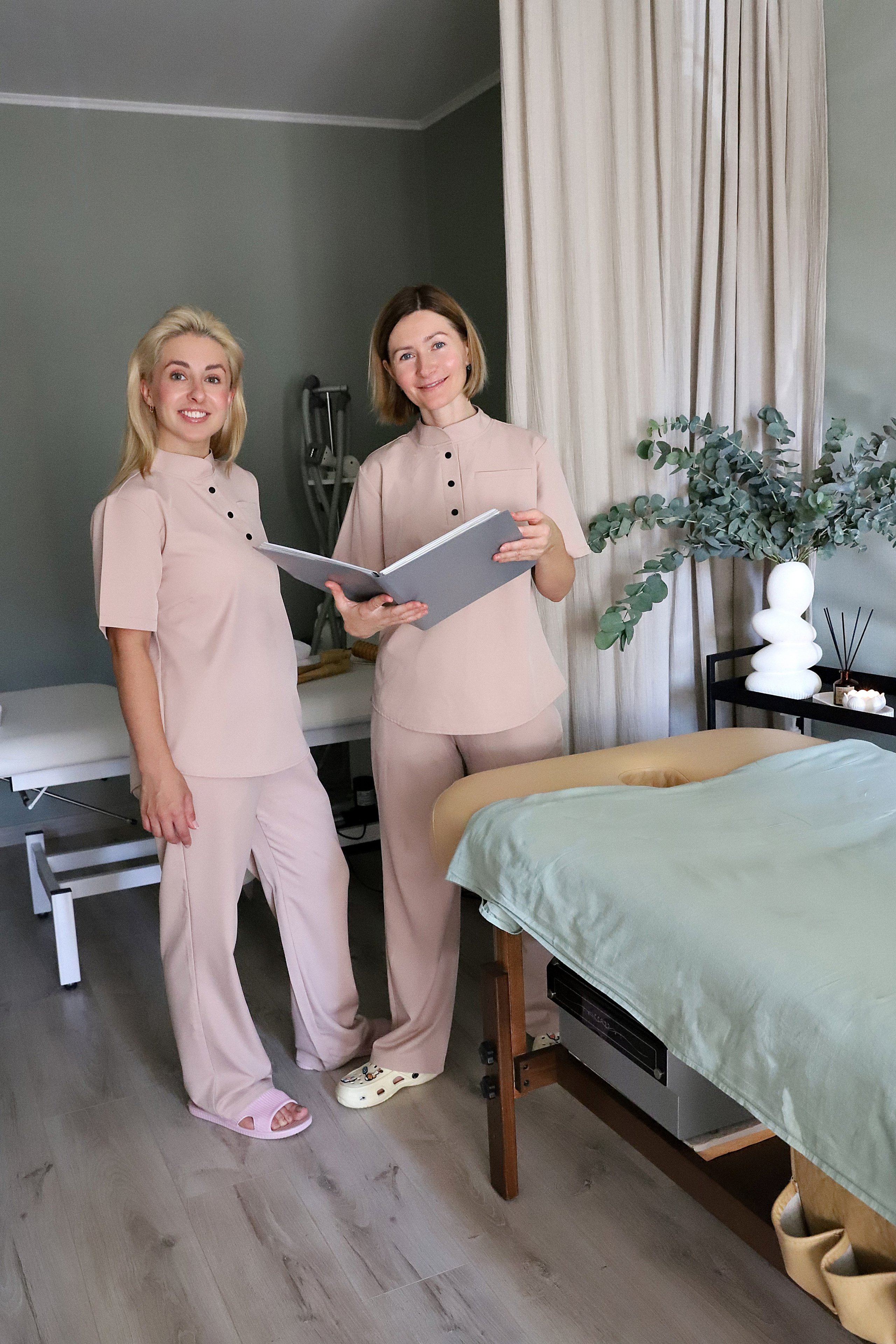 Массажист демонстрирует технику массажа, объясняя ее клиенту во время сеанса релаксации.