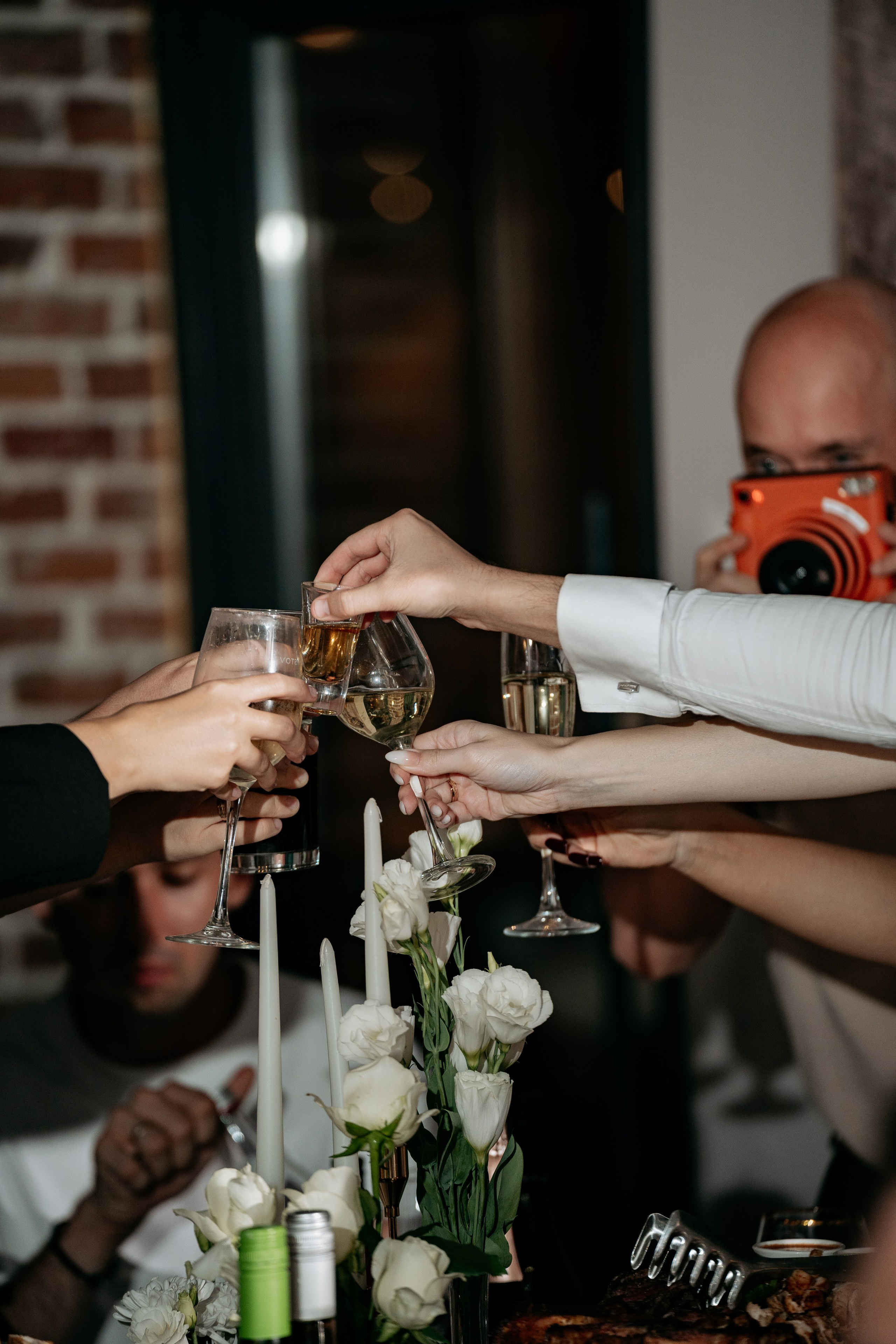 Свадебная фотография на банкете — Романтический момент пары за столом между тостами.