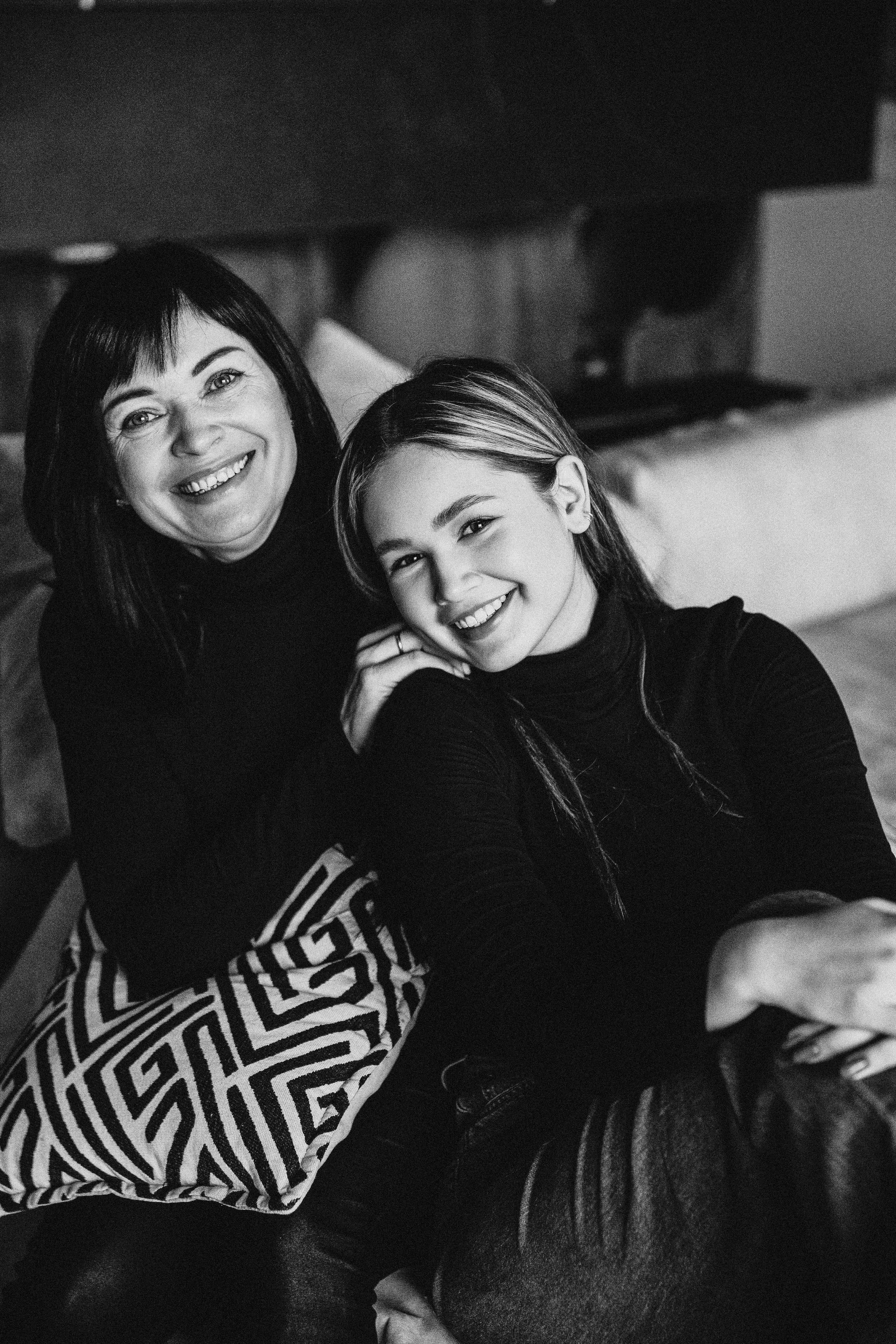 мама с дочкой сидят на диване и улыбаются друг друг осенью