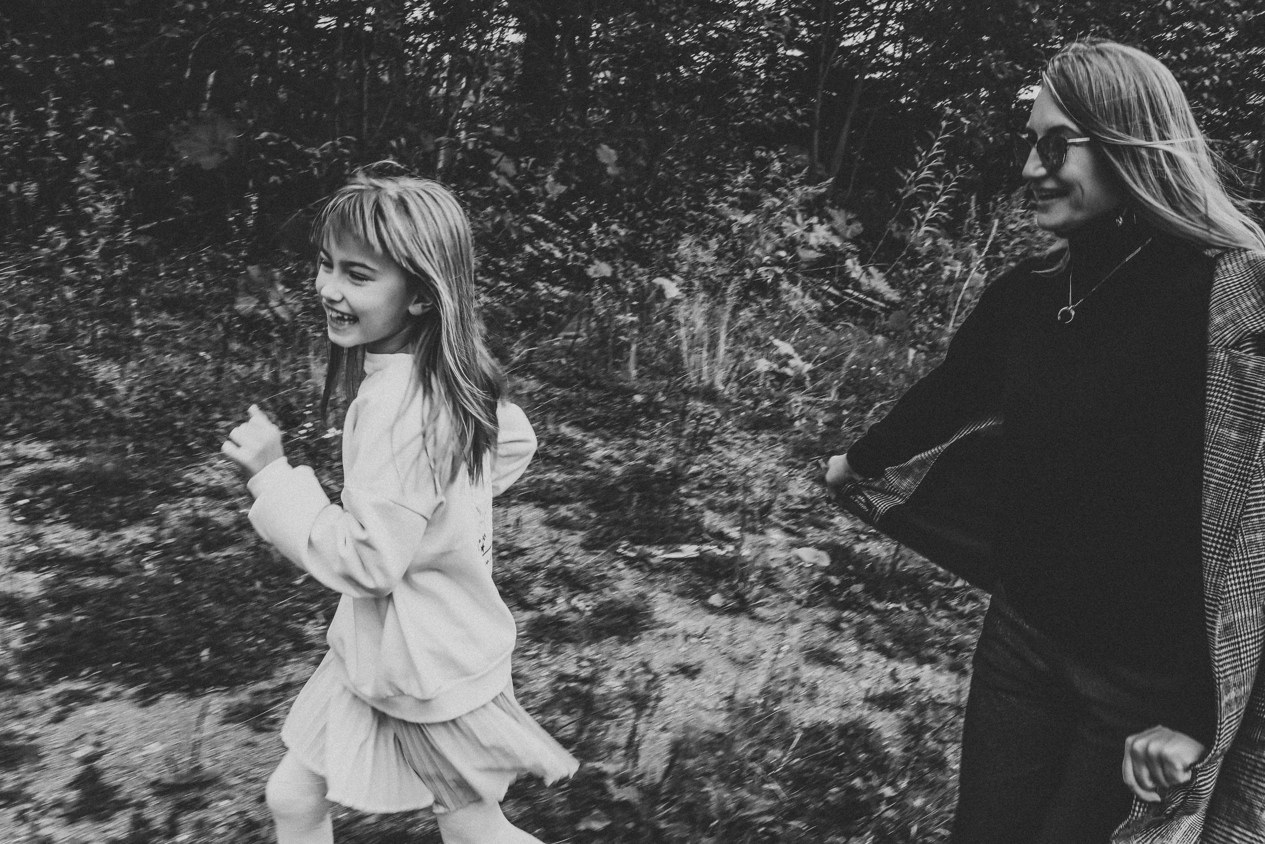 мама и дочка играют в догонялки на улице