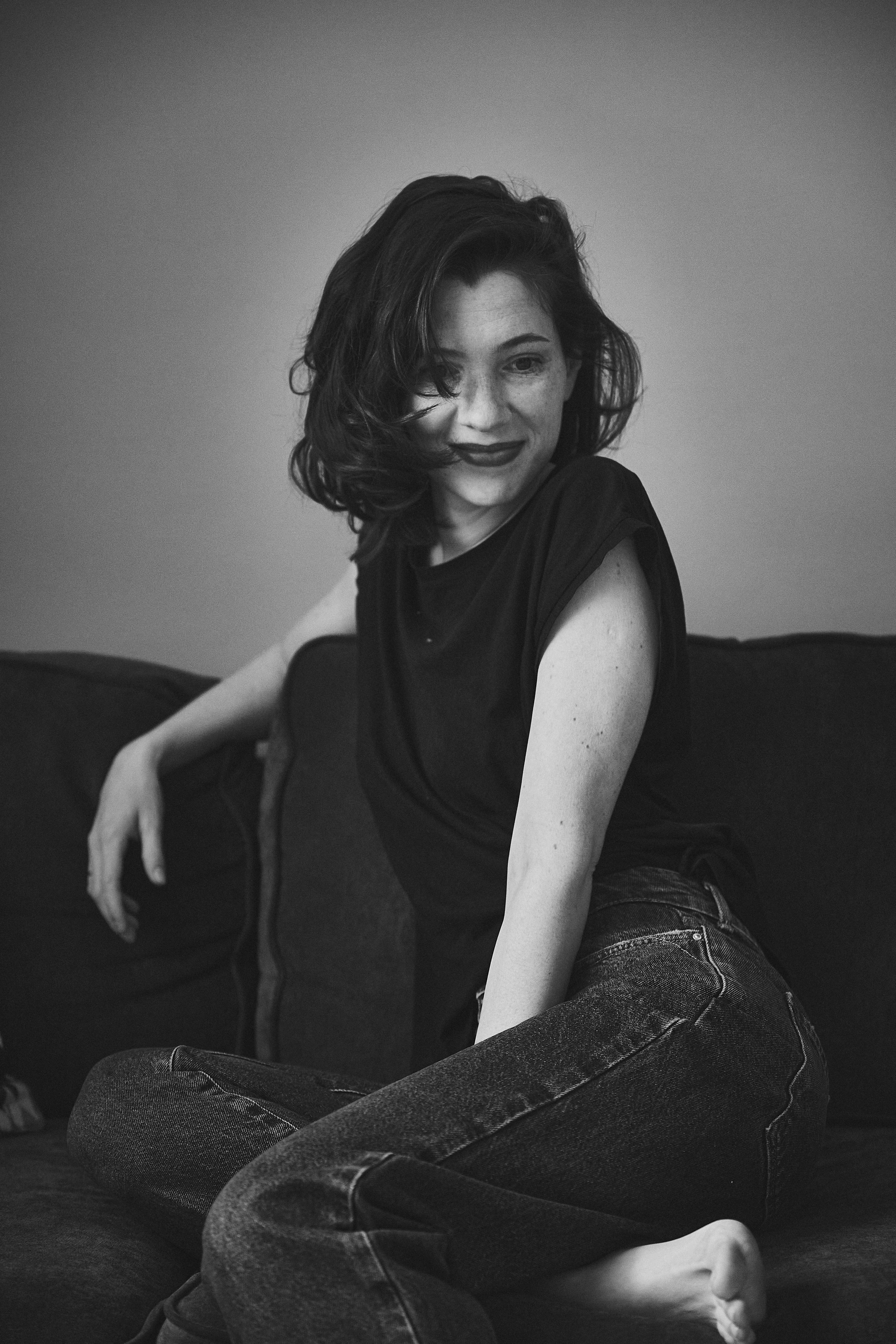 Красивая девушка с темными волосами на диване