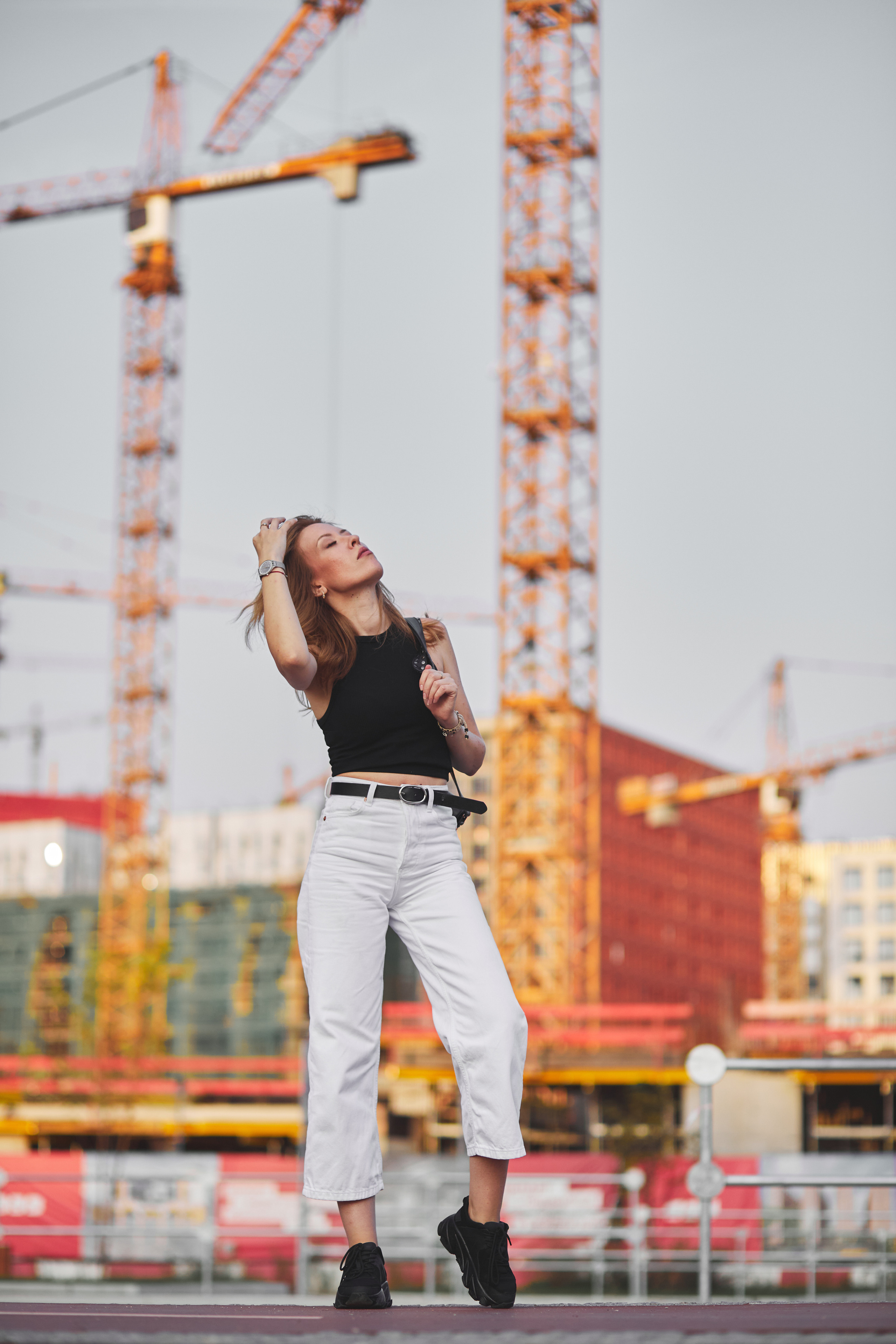 Красивая рыжеволосая девушка на фоне строительства жилого дома