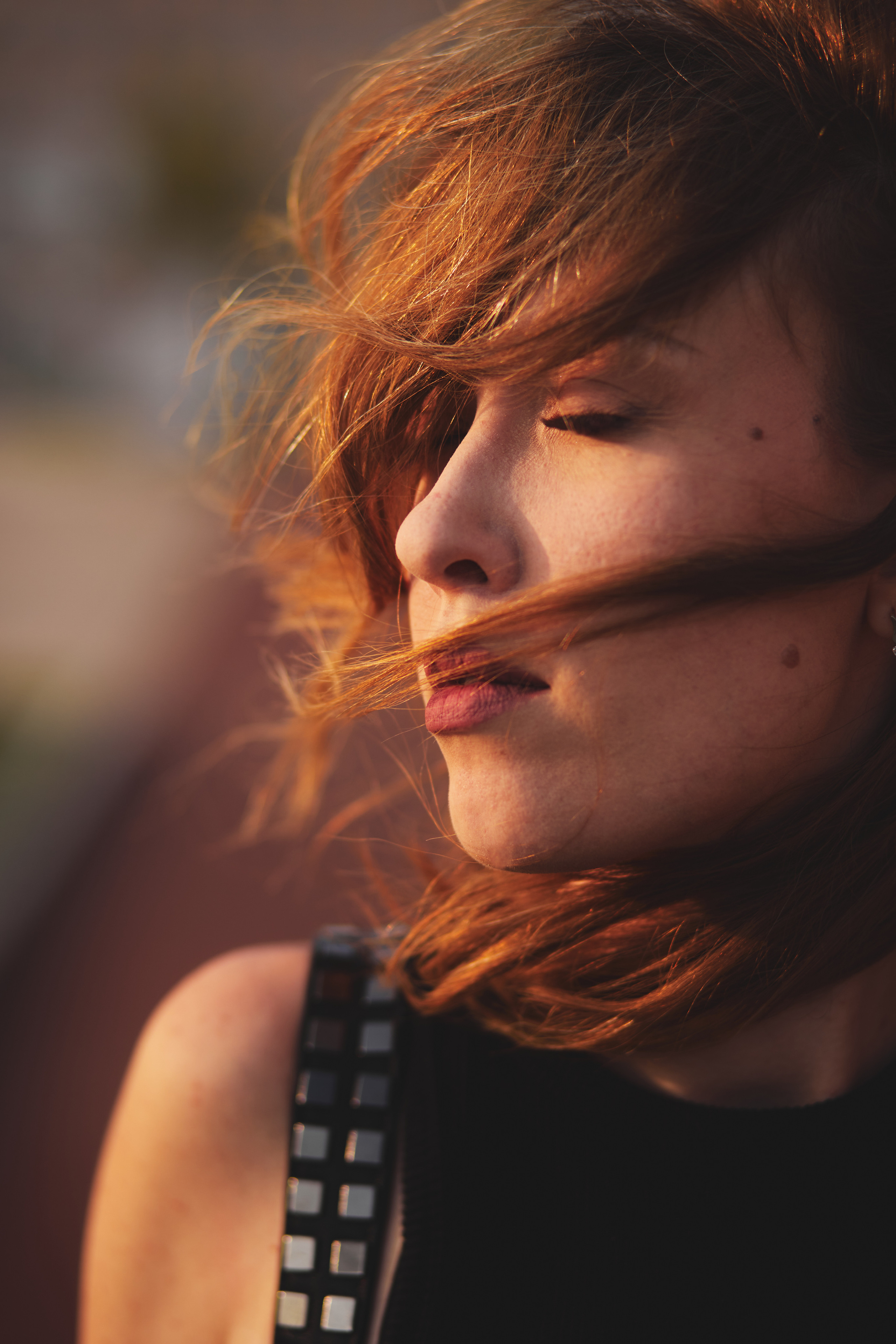 Красивая рыжеволосая девушка, волосы которой развивает ветер