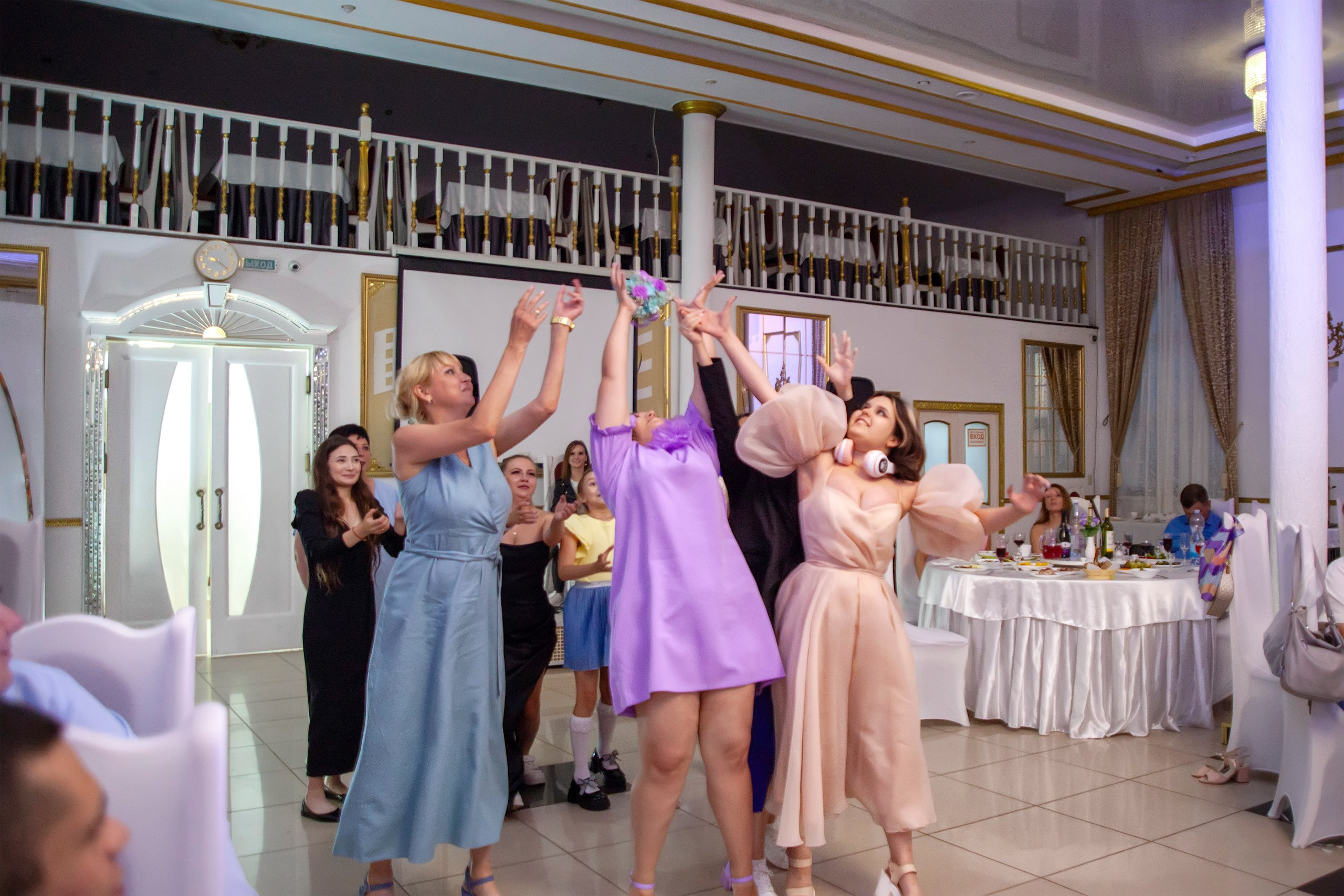 Девушки на свадьбе ловят букет невесты