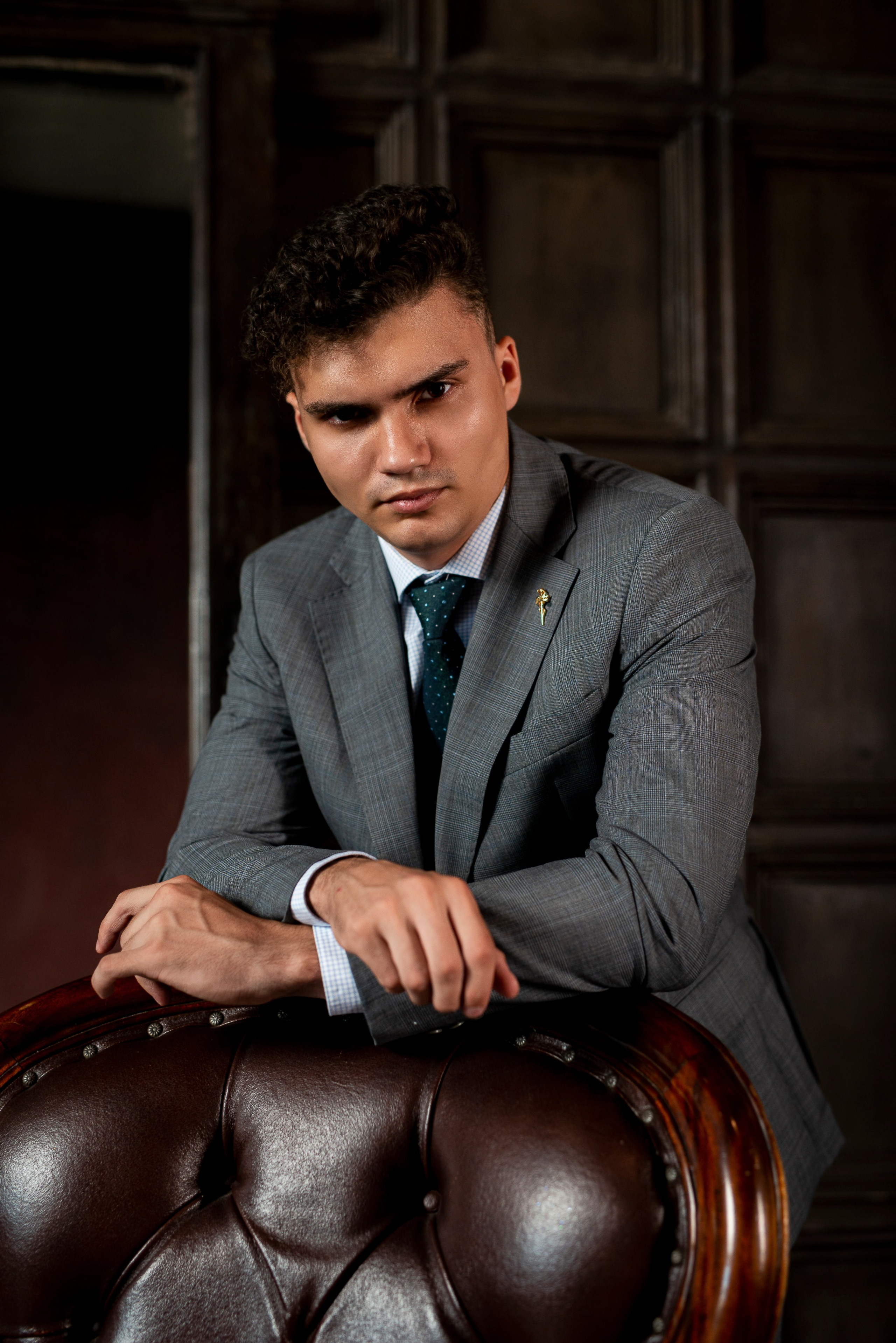 Мужчина облокотился на кресло во время съёмки