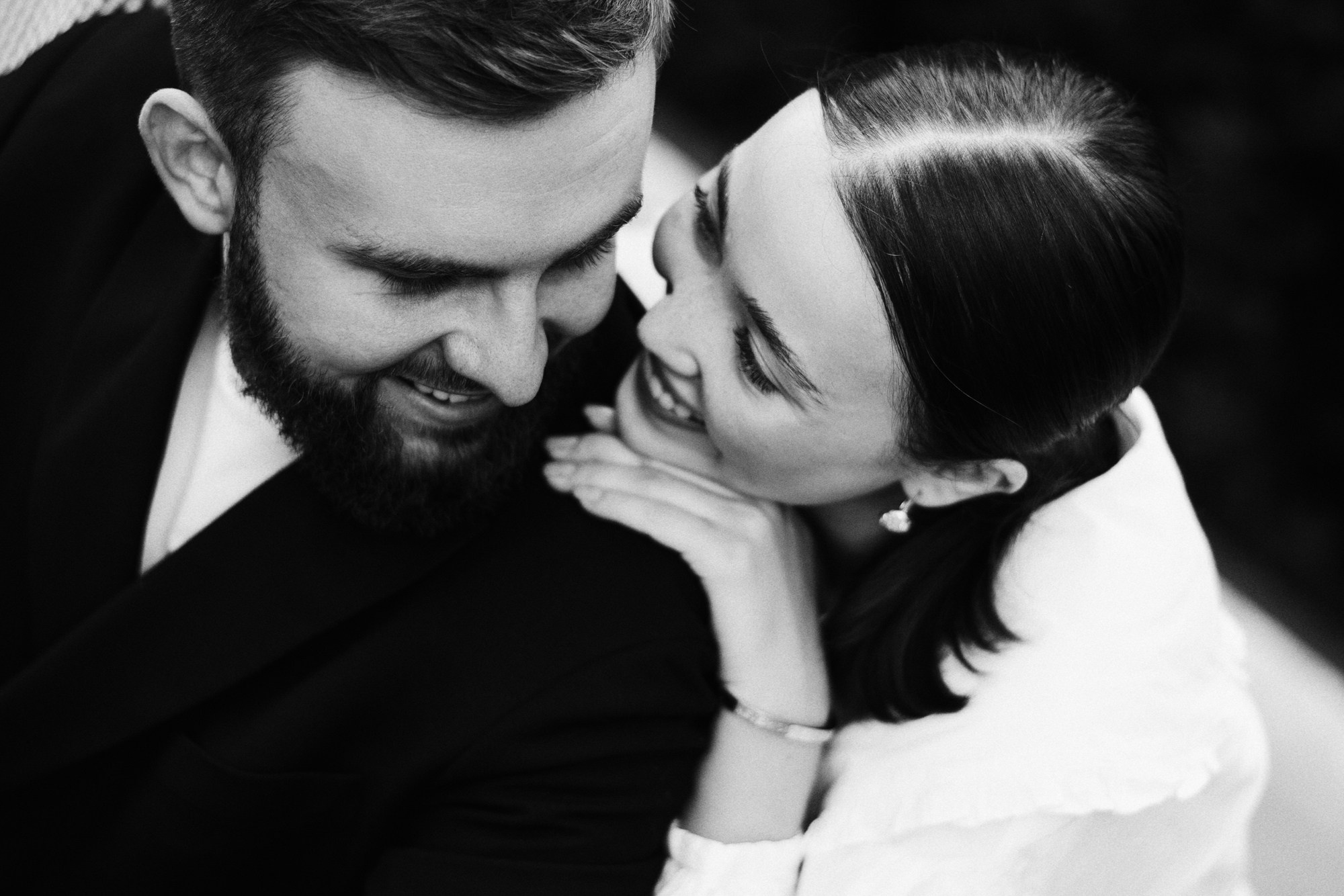 Крупный план смеющихся молодоженов на фоне яблоневого сада, искренние эмоции на свадьбе