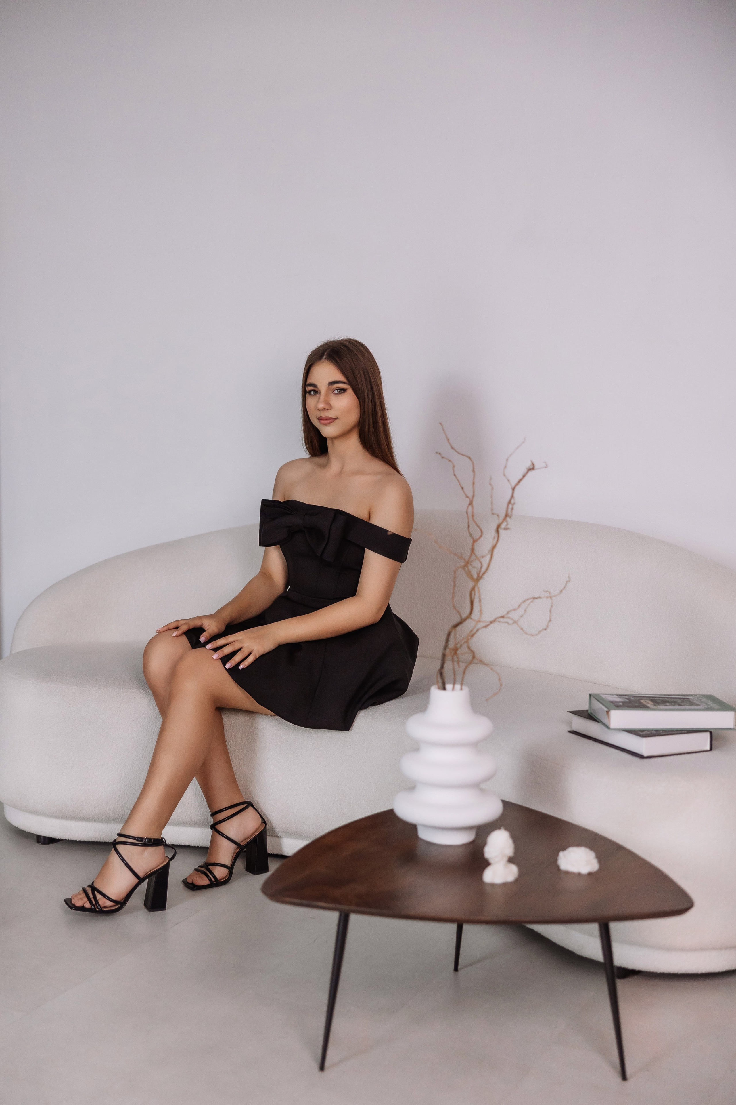 Гламурная студийная фотосессия — девушка в черном платье на белом фоне