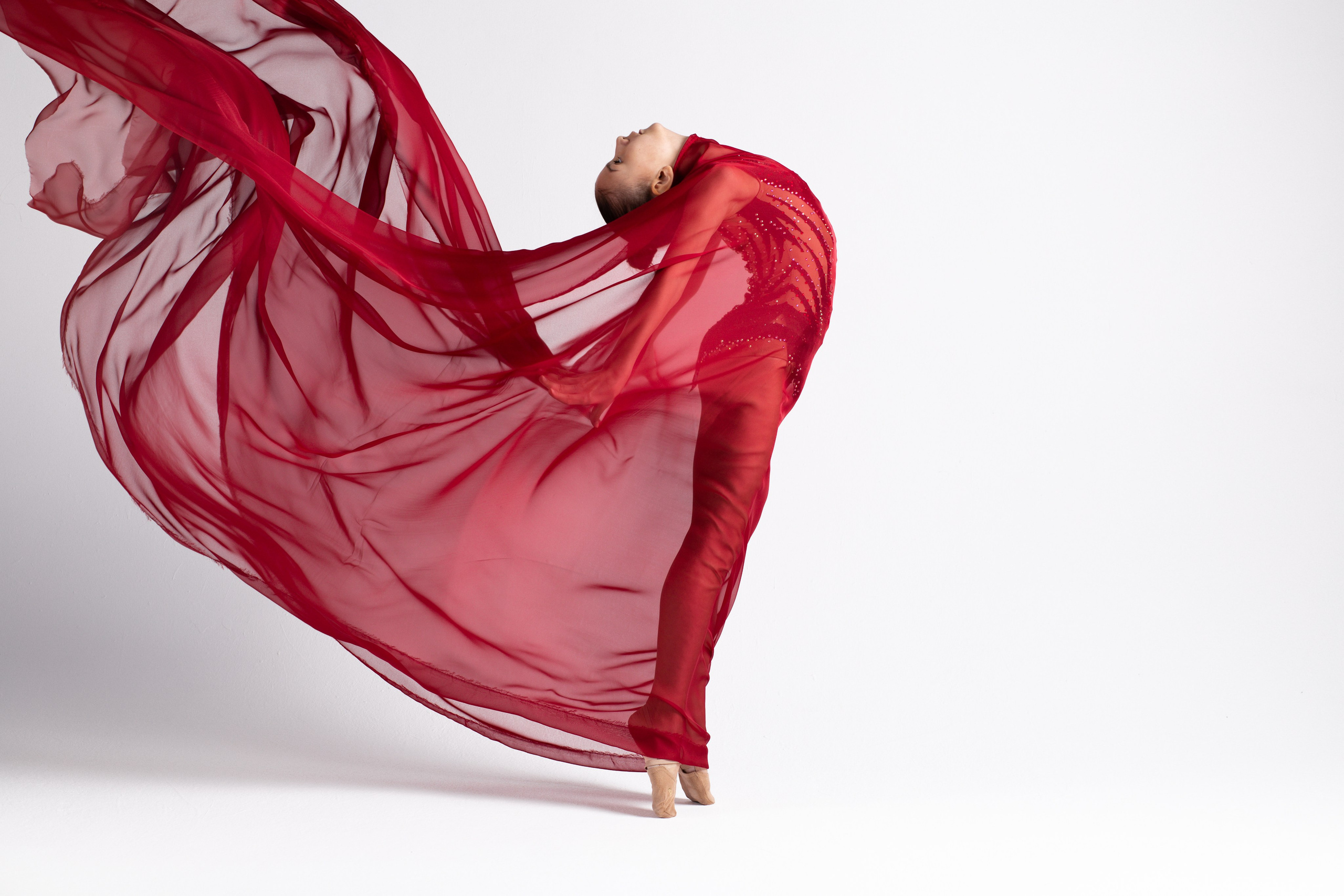 Фотосессия с красной тканью девочки гимнастки.