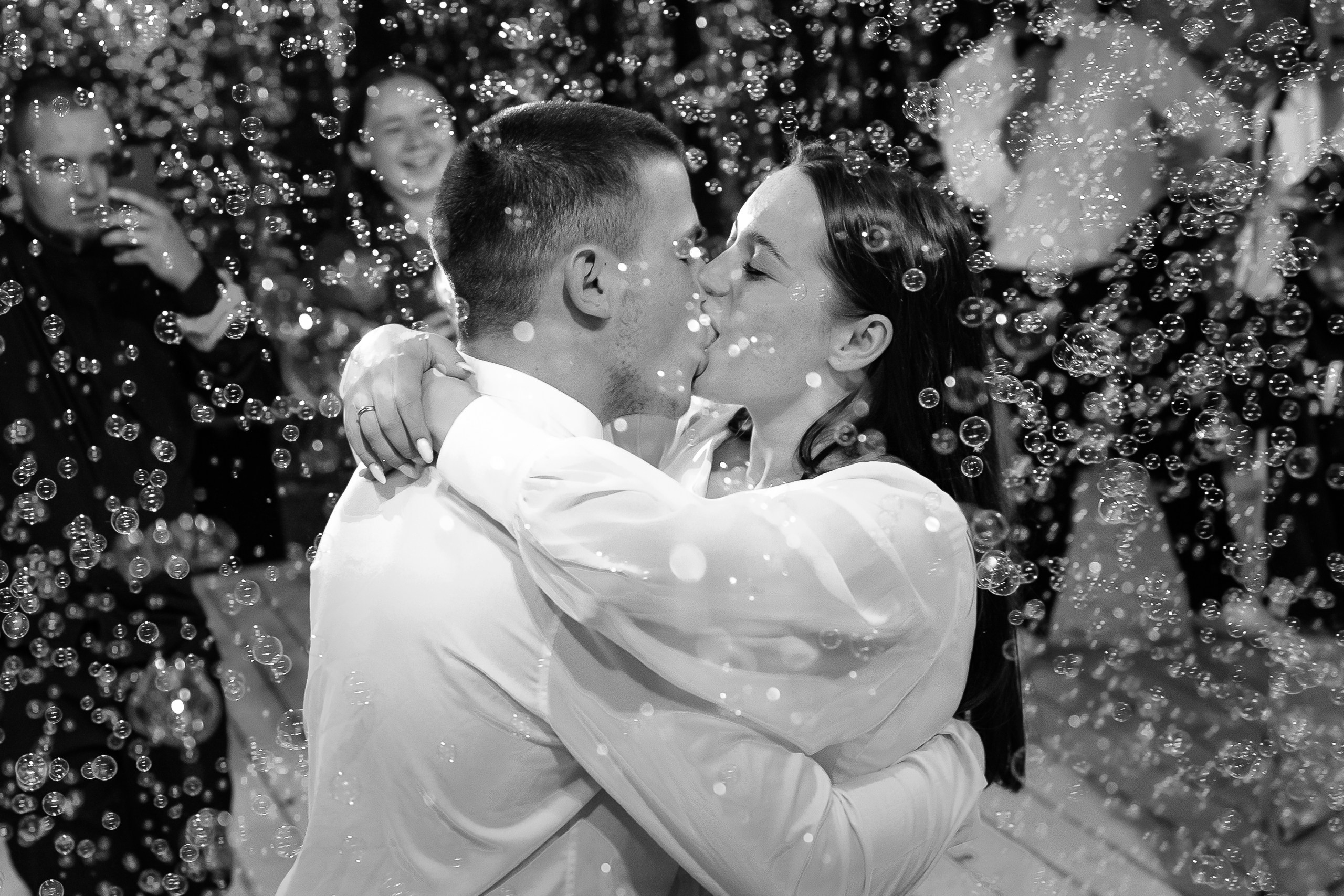 Жених и невеста танцуют среди мыльных пузырей
