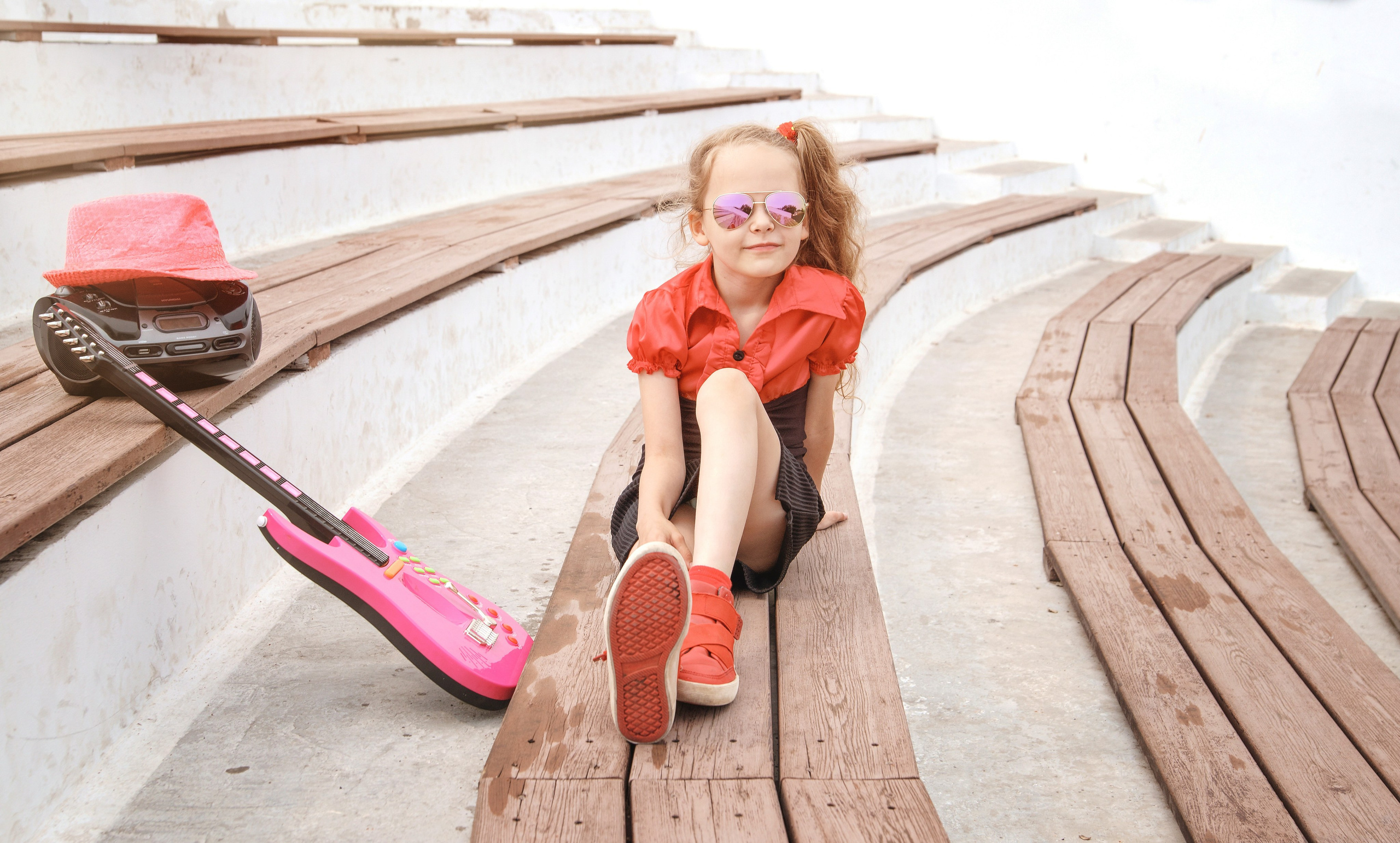 Детская фотосессия летом - девочка сидя с магнитофоном и гитарой
