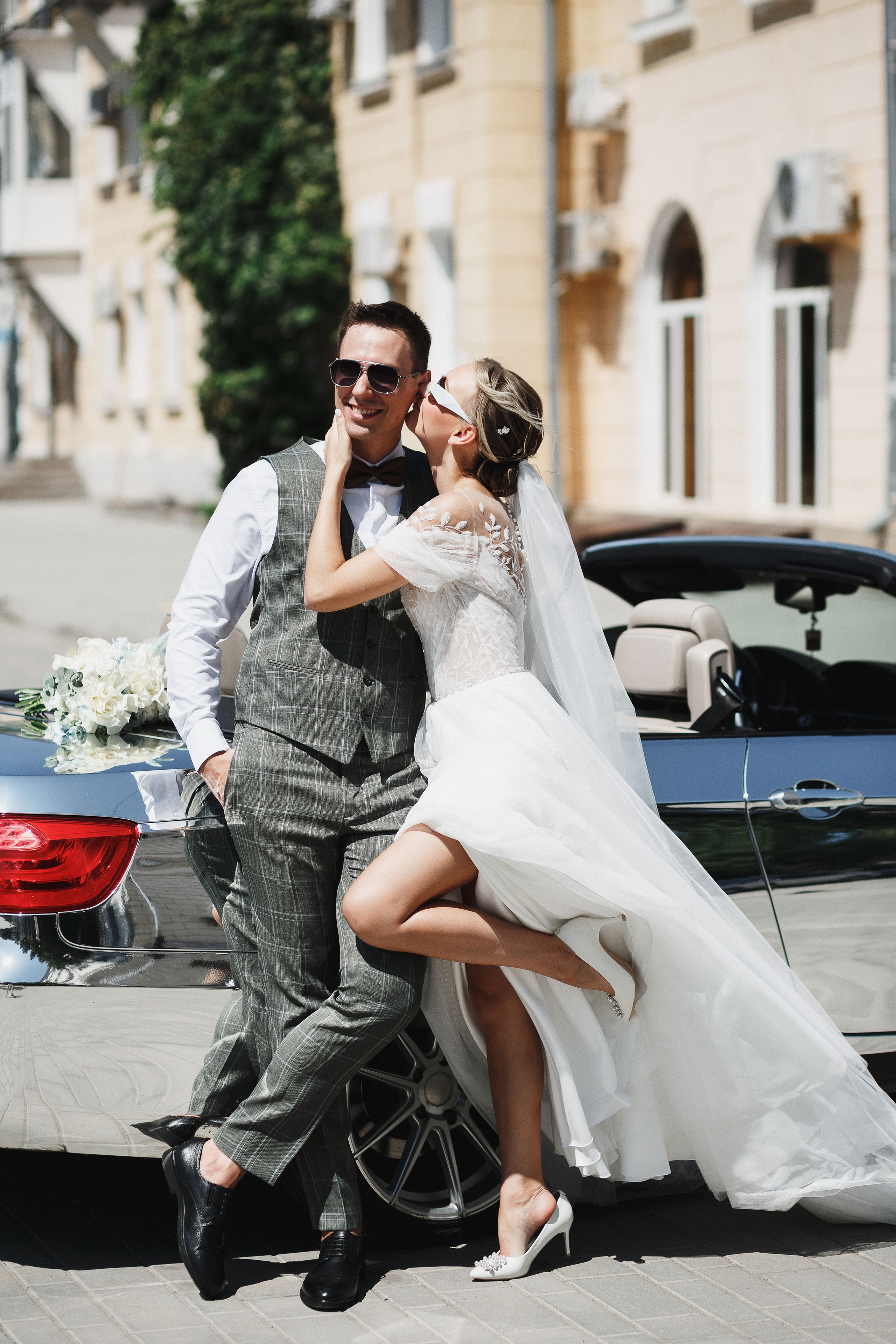 Свадебная прогулка в Таганроге: Веселые моменты на фоне элегантной машины. Романтическая атмосфера и незабываемые впечатления в день свадьбы.