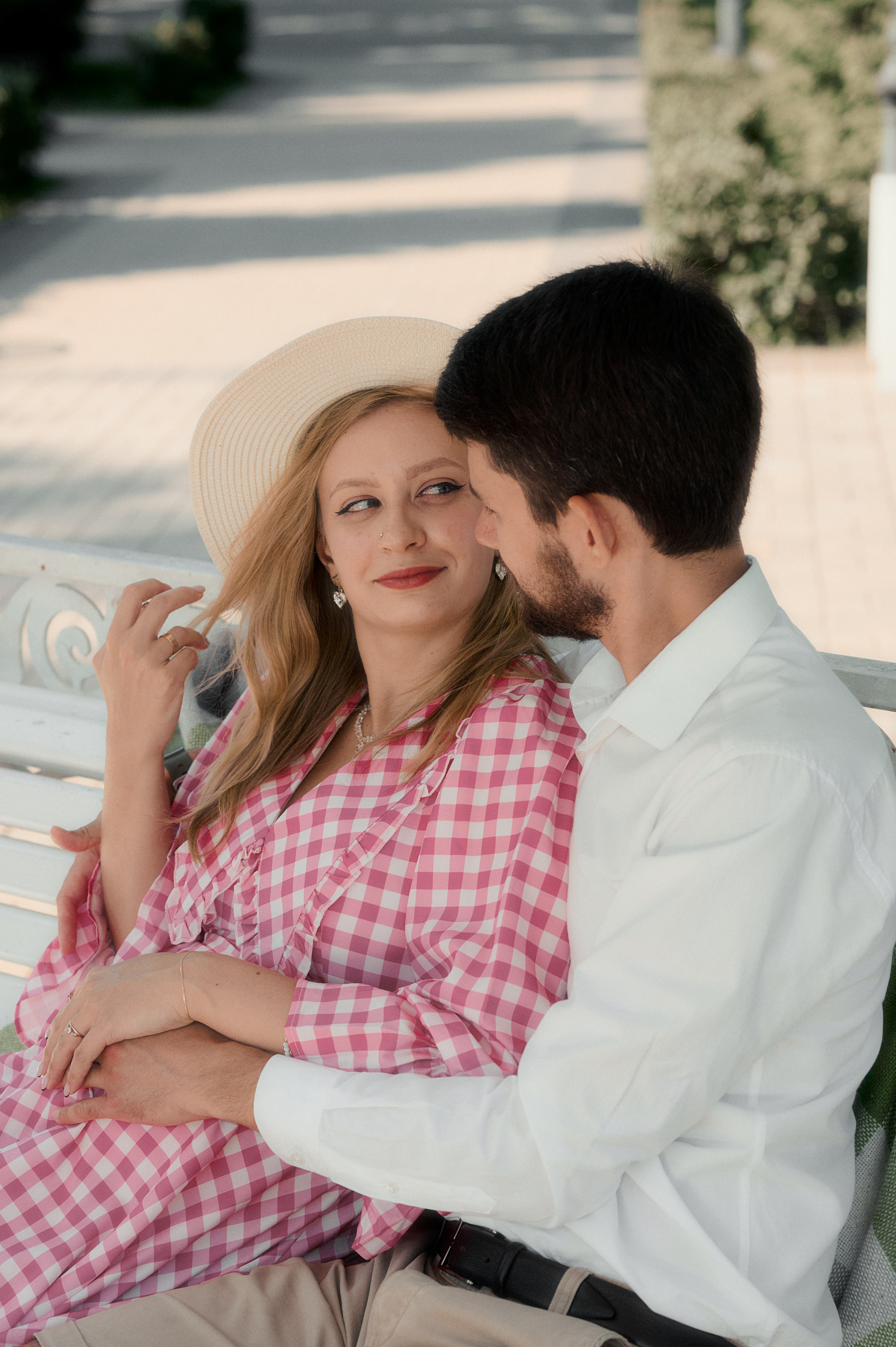 Юрий сидит на скамейке, обнимая Елизавету в шляпе.