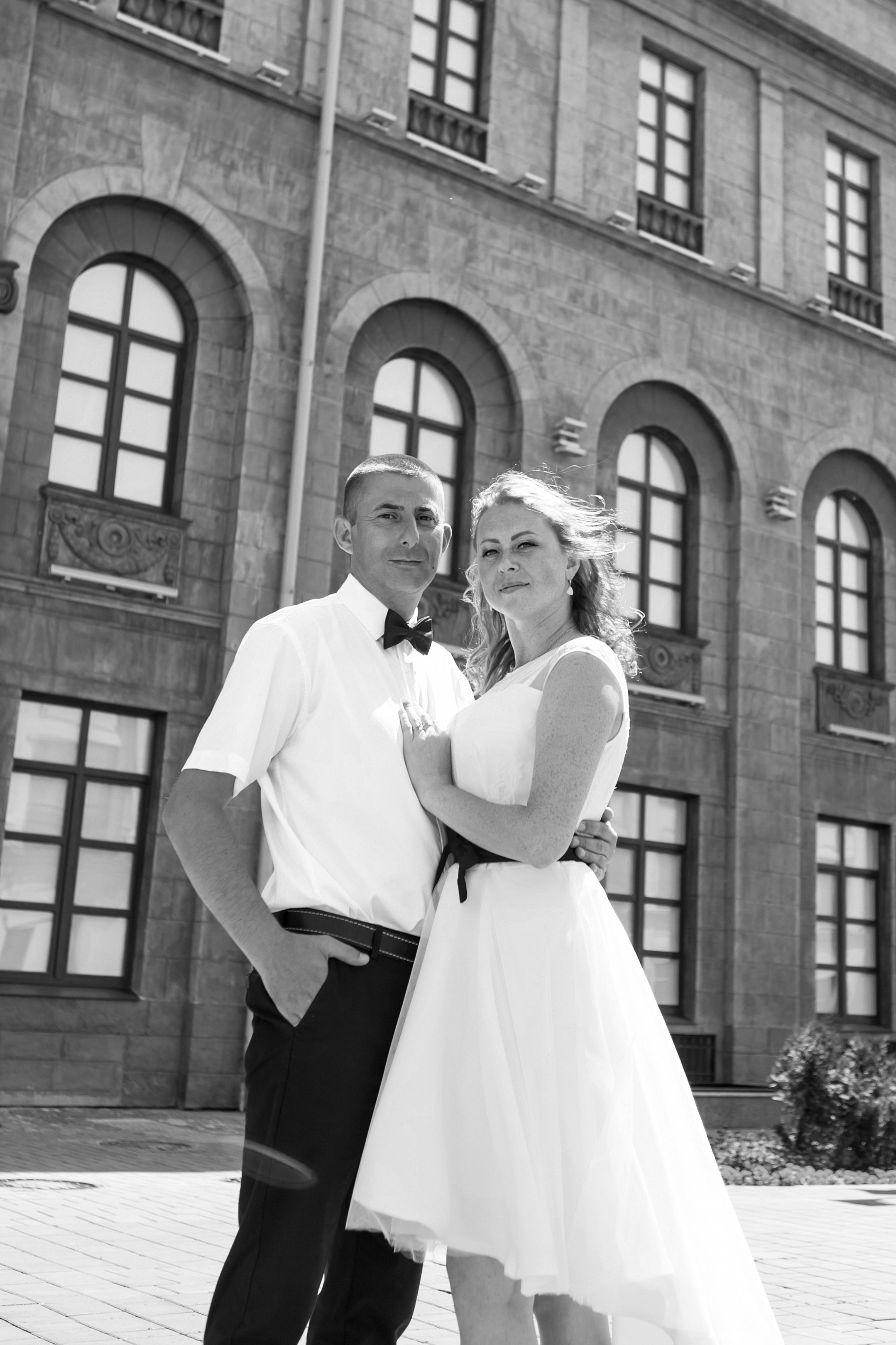 Жених и невеста в летний солнечный день на фоне красивого исторического здания