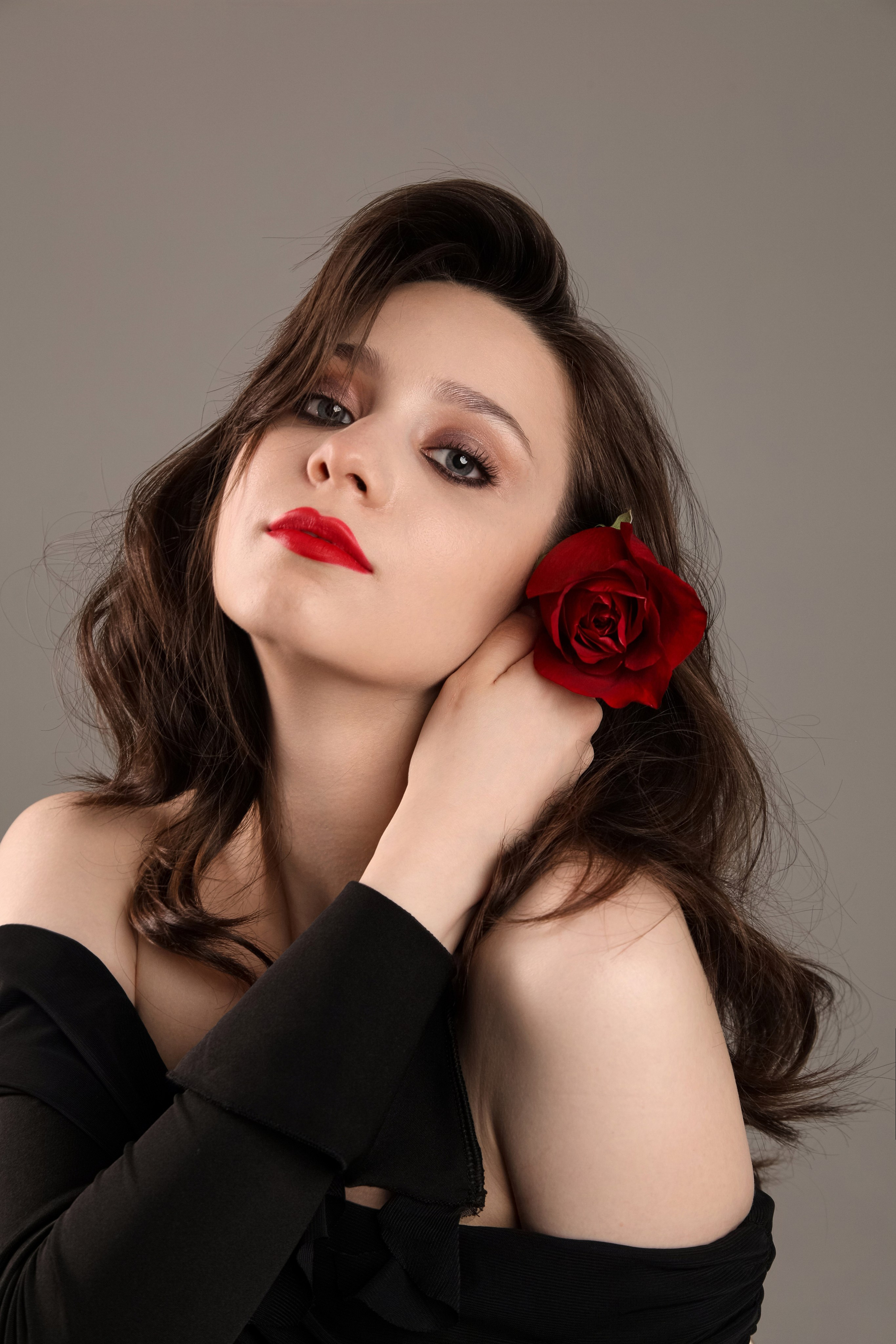 Студийный портрет красивой девушки в черном платье с красной розой и красной помадой Иваново