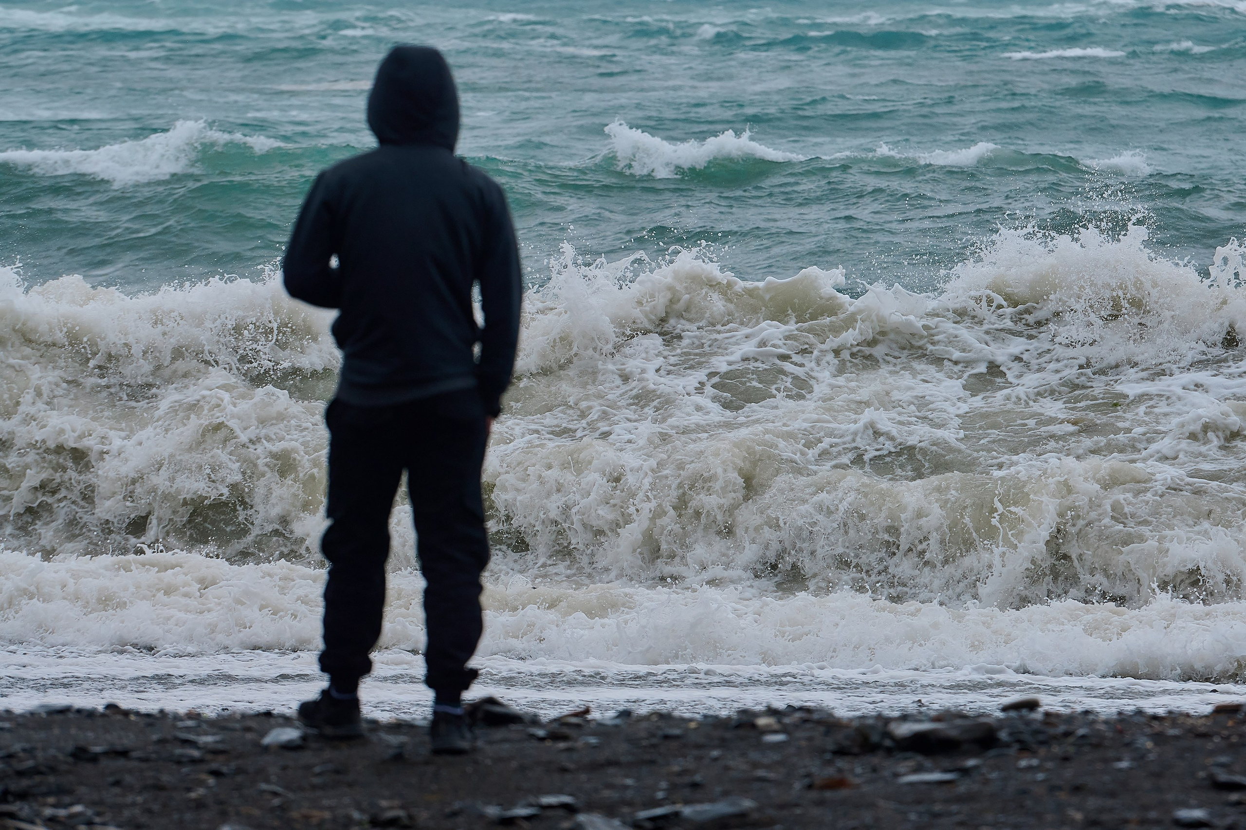 Парень, пьющий кофе и наблюдающий за штормом, на пляже в п. Большой Утриш