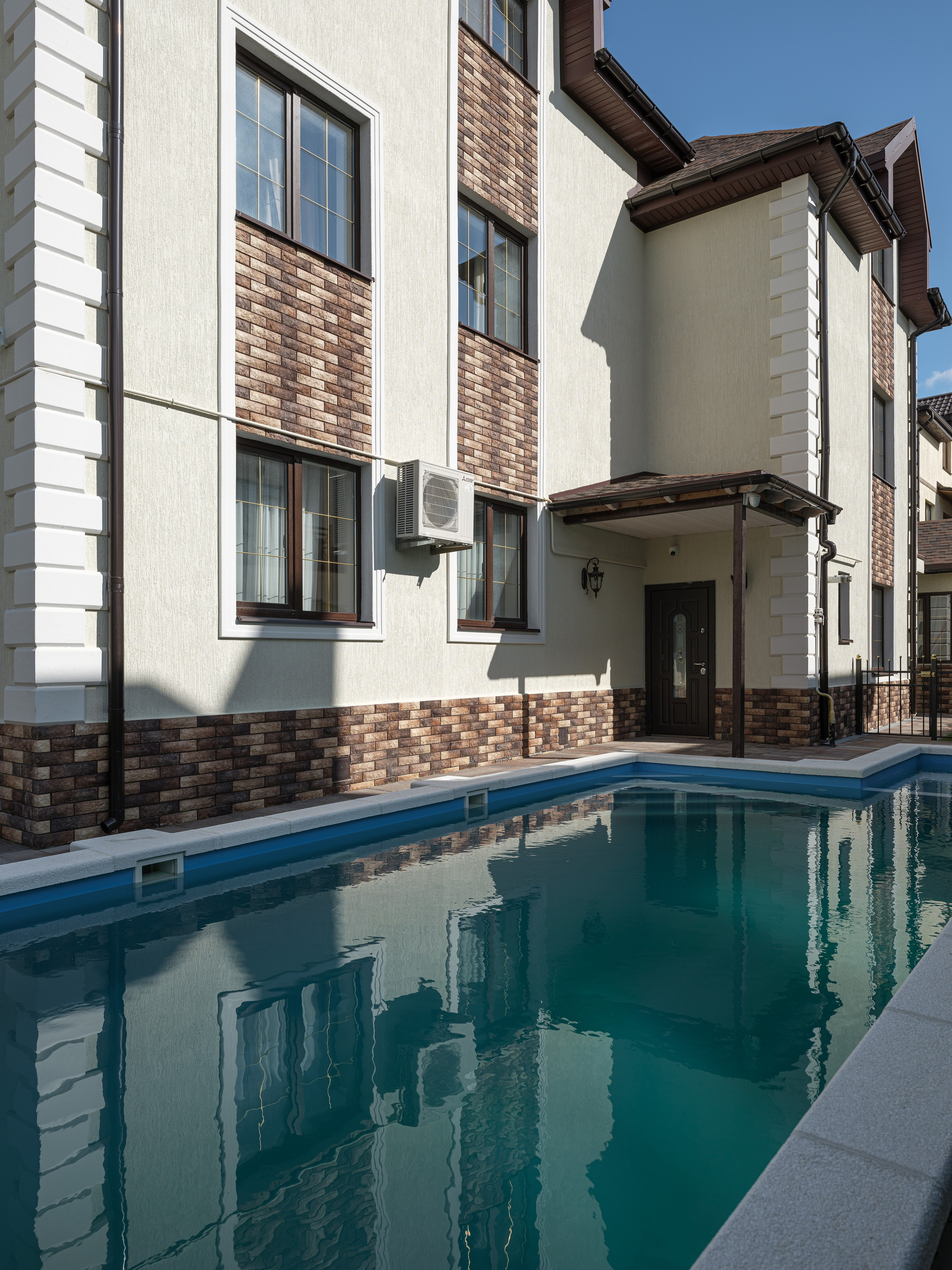 Фасад современного частного дома с бассейном во дворе, гармоничное сочетание отделки и архитектуры. Стильный проект с атмосферой уюта и комфорта. Дизайнер Татьяна Диденко, фотограф Сергей Денисенко, стилист Наталья Якушева.