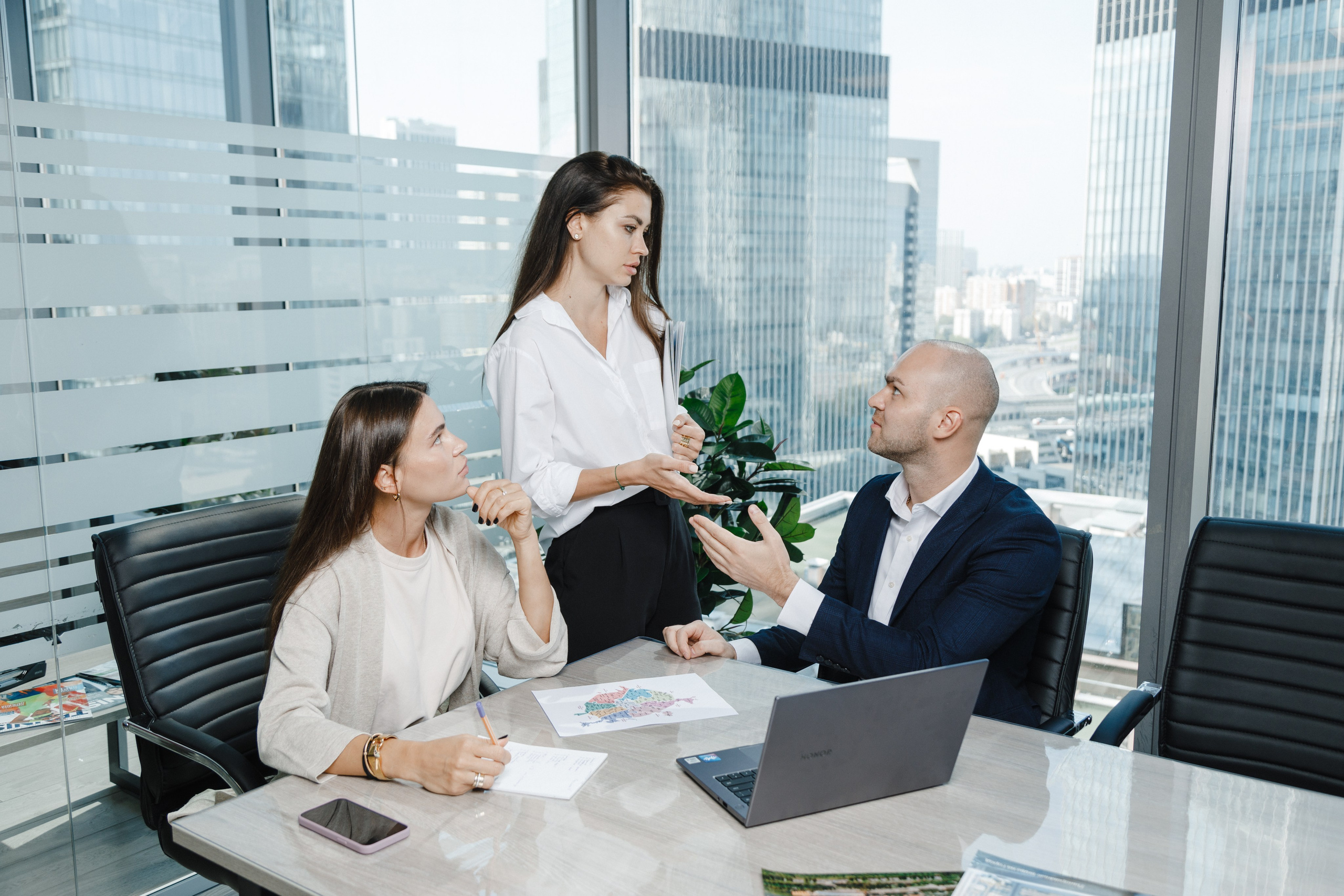 Совещание рабочей группы в переговорной комнате с видом на Москва-Сити.