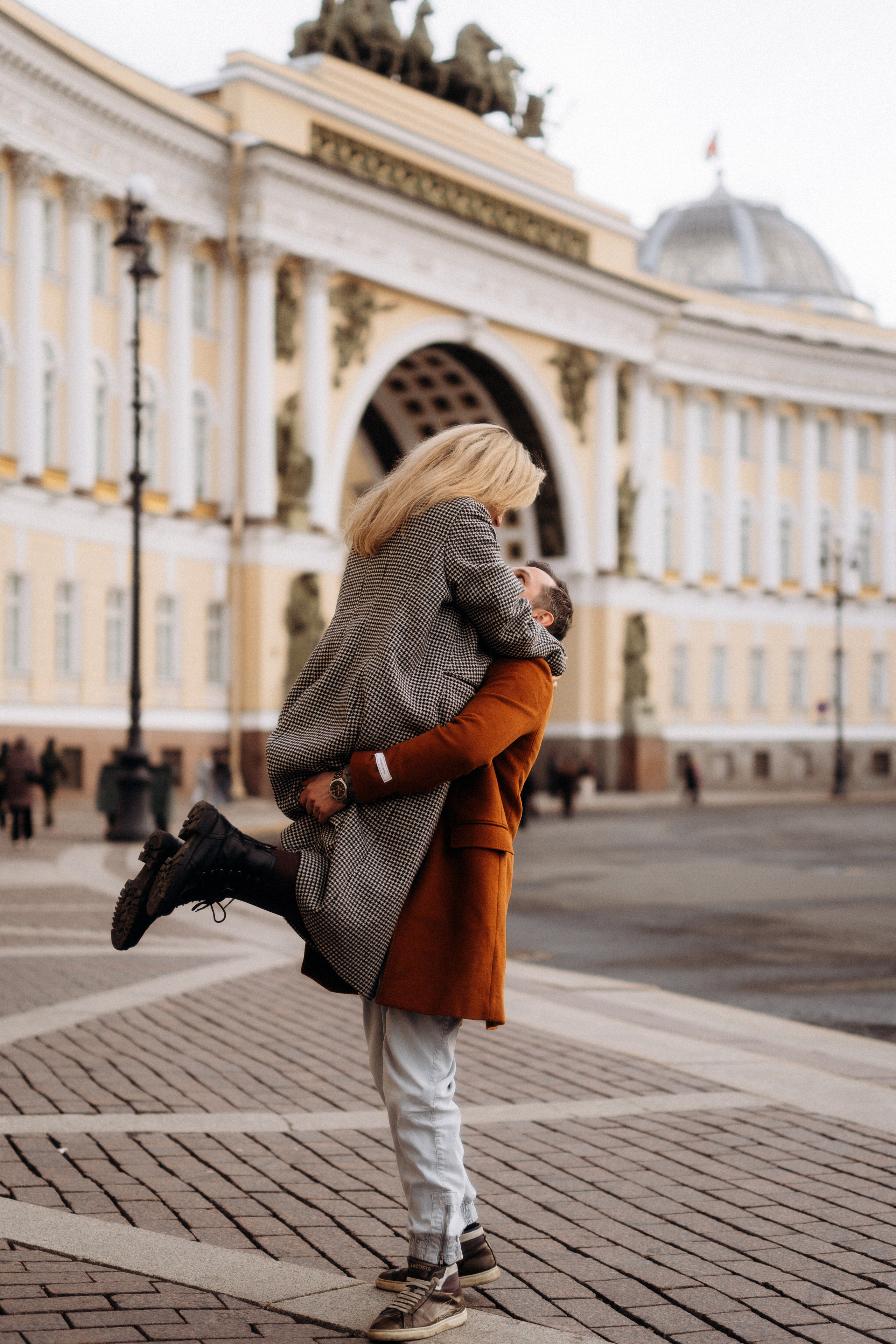 Лавстори Love Story в Санкт-Петербурге с атмосферой города. Пара обнимается на Дворцовой площади. 