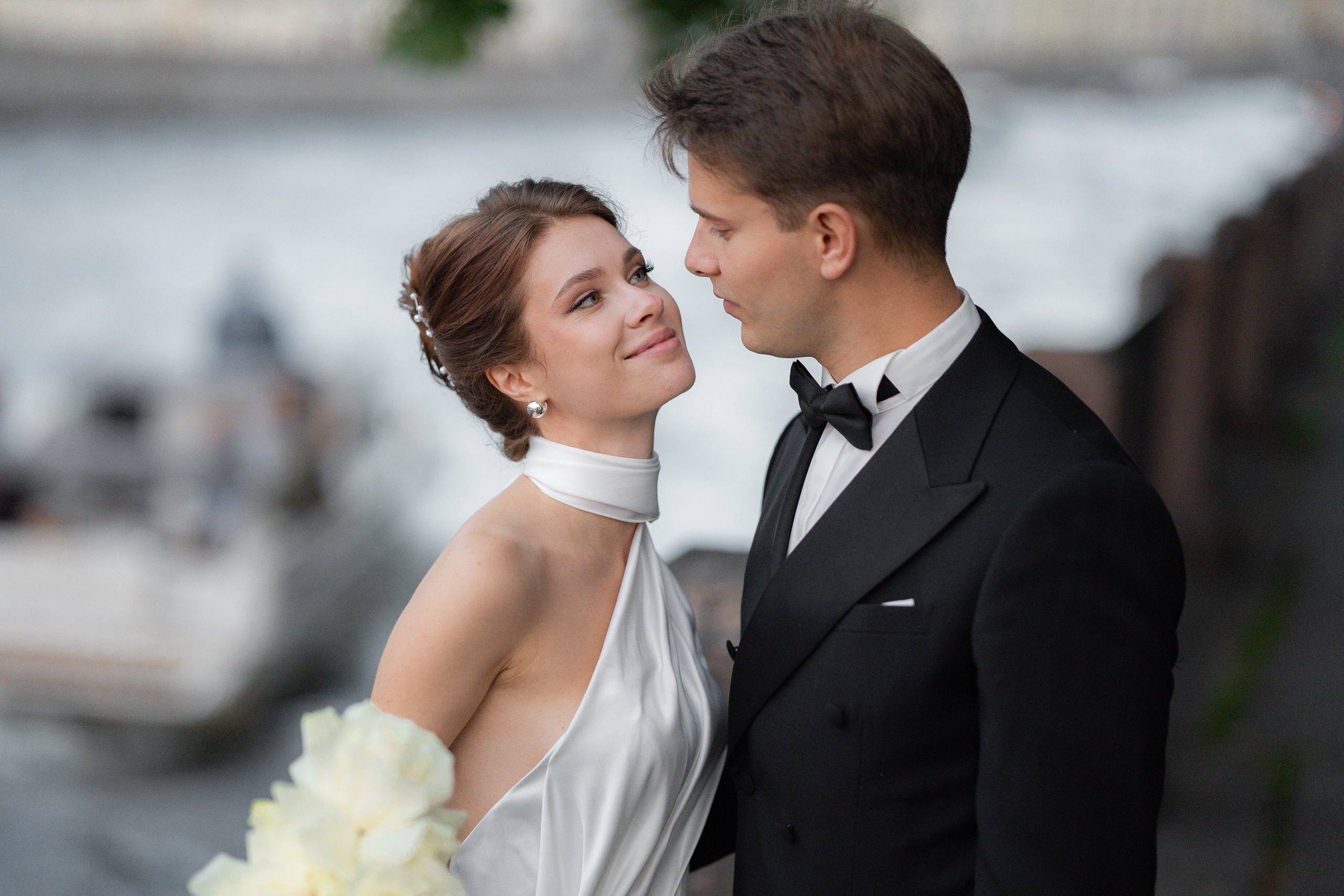 невеста рядом с женихом в Летнем саду на закате солнца на вечерней свадебной фотосессии