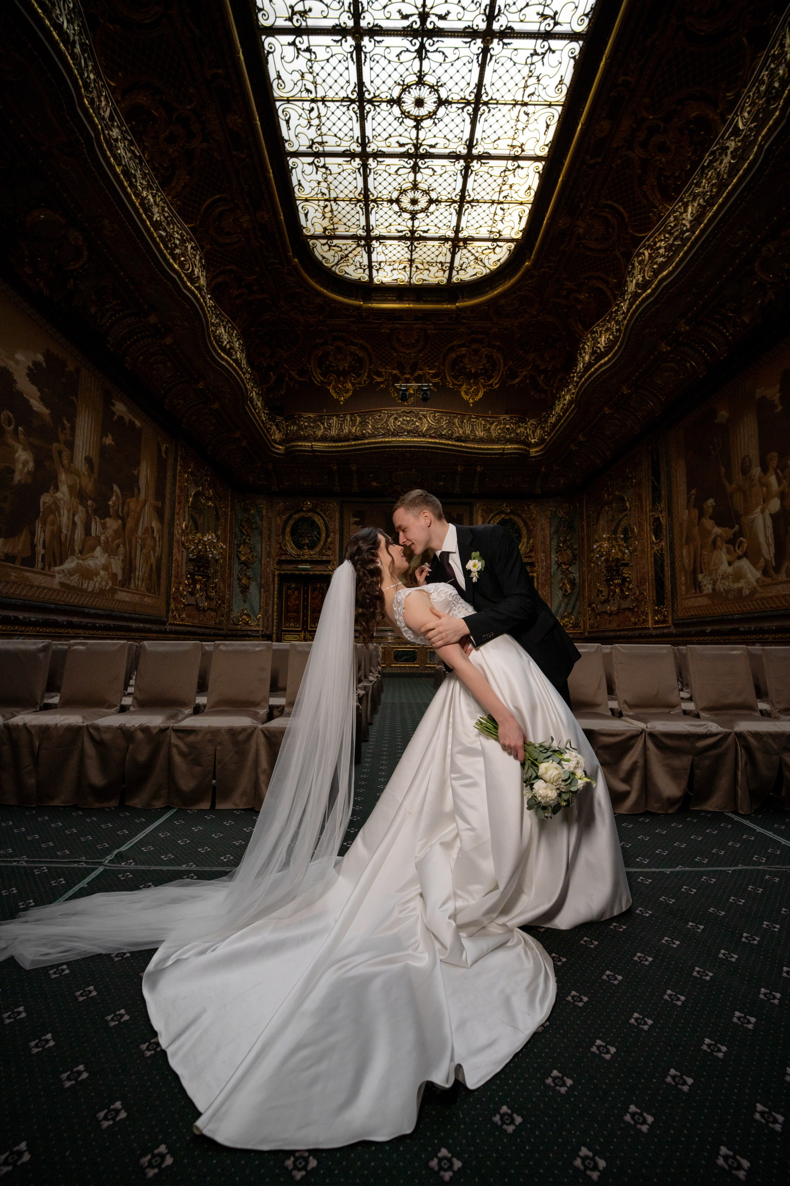 Свадебная фотосессия в Санкт-Петербурге в Особняке Половцева или Дом Архитектора. Жених красиво целует невесту в зале театра.