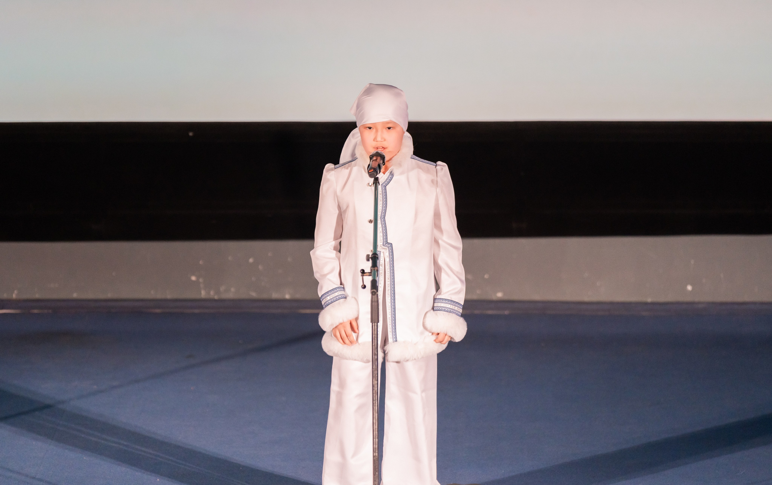 Мальчик  в белом северном национальном костюме исполняет номер на XII Международном фольклорном фестивале «Сохраняем традиции» Санкт-Петербург 2026. Фото: Мальцев Евгений, evrednix.ru