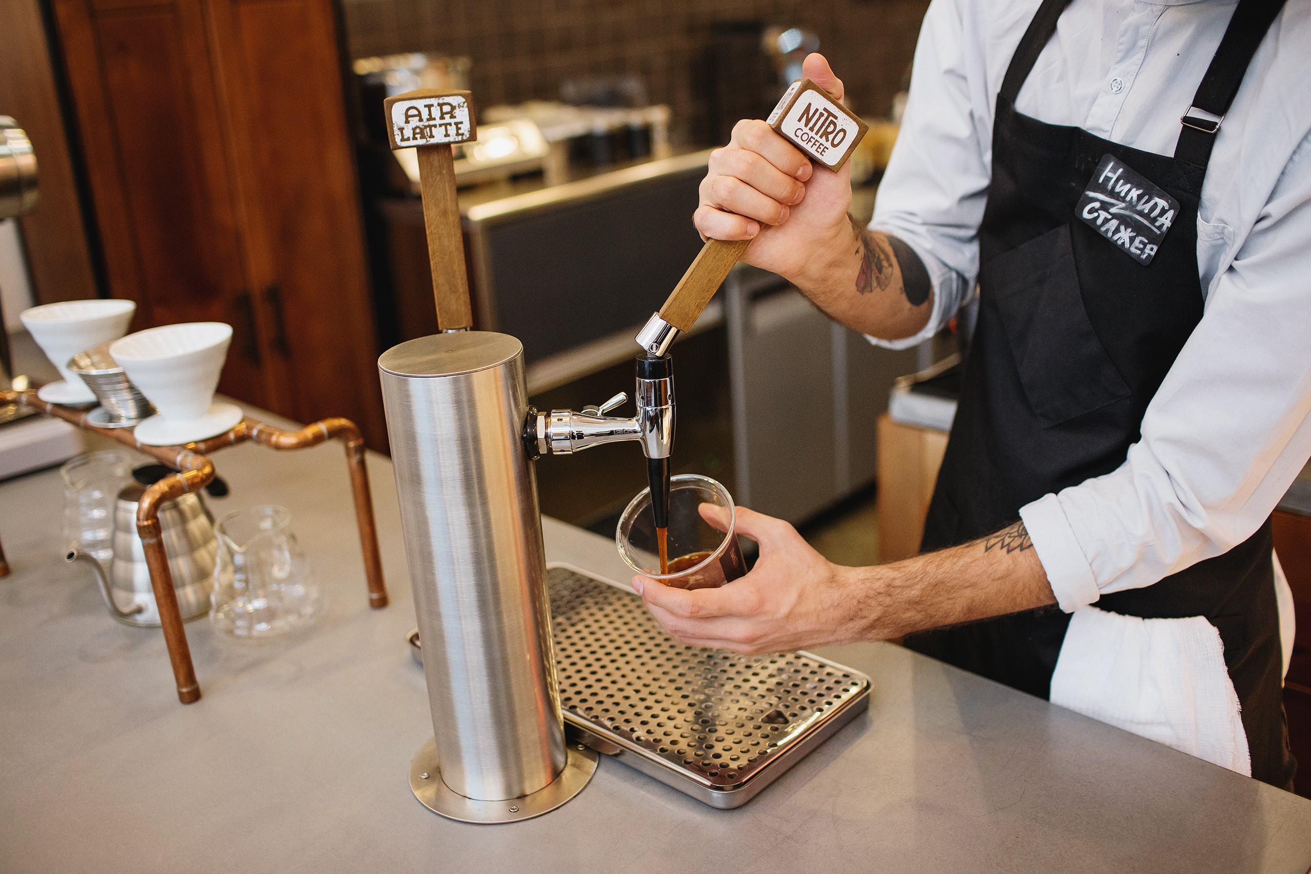 Бариста в кофейне наливает нитро кофе
