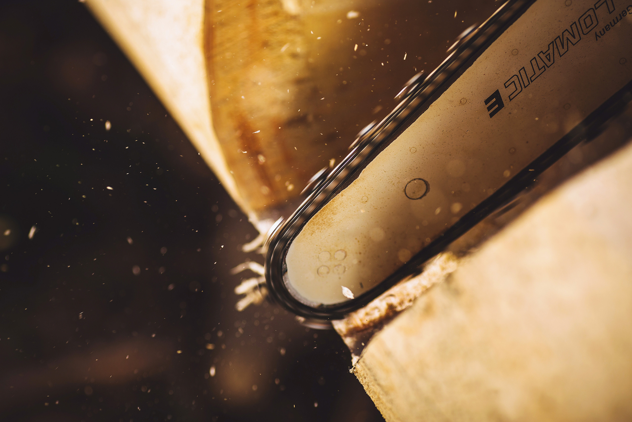 Строитель обрабатывает брус бензопилой