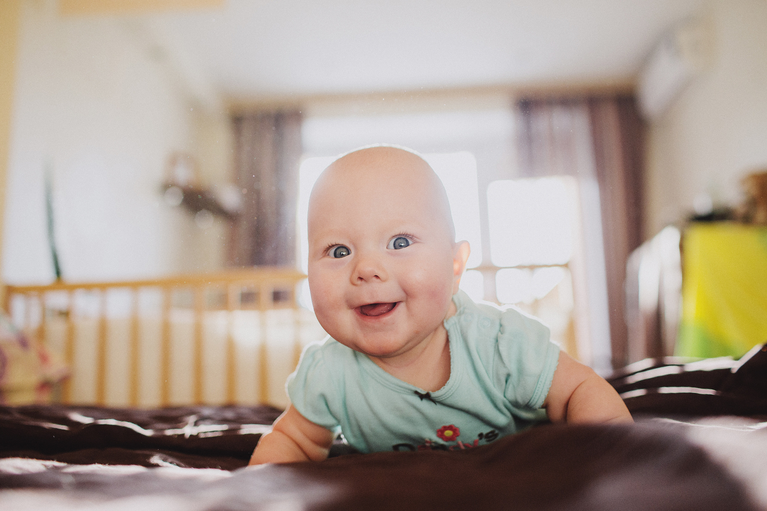 Счастливый младенец ползёт по кровати