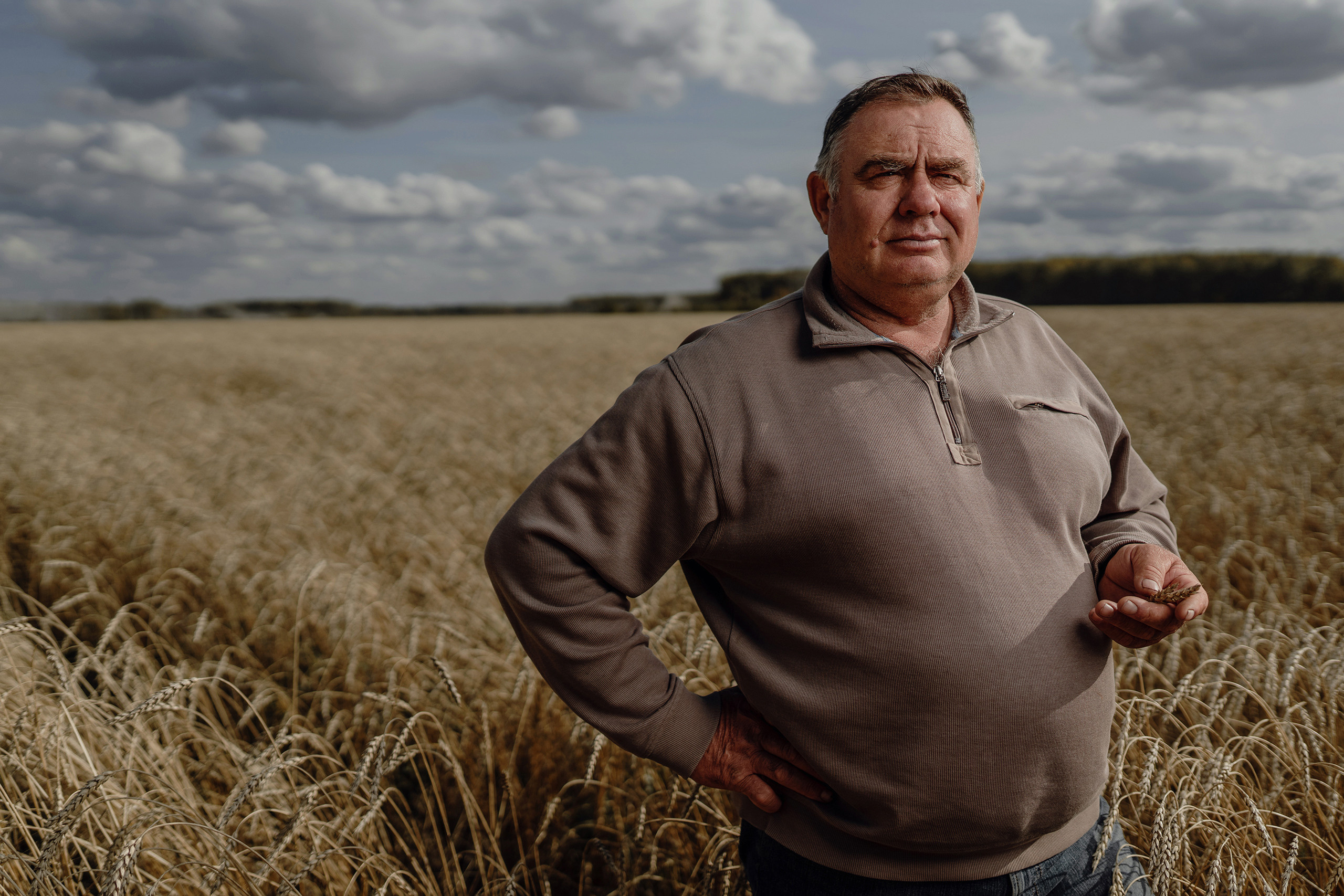 мужчина стоит в поле пшеницы портретная фотосъёмка