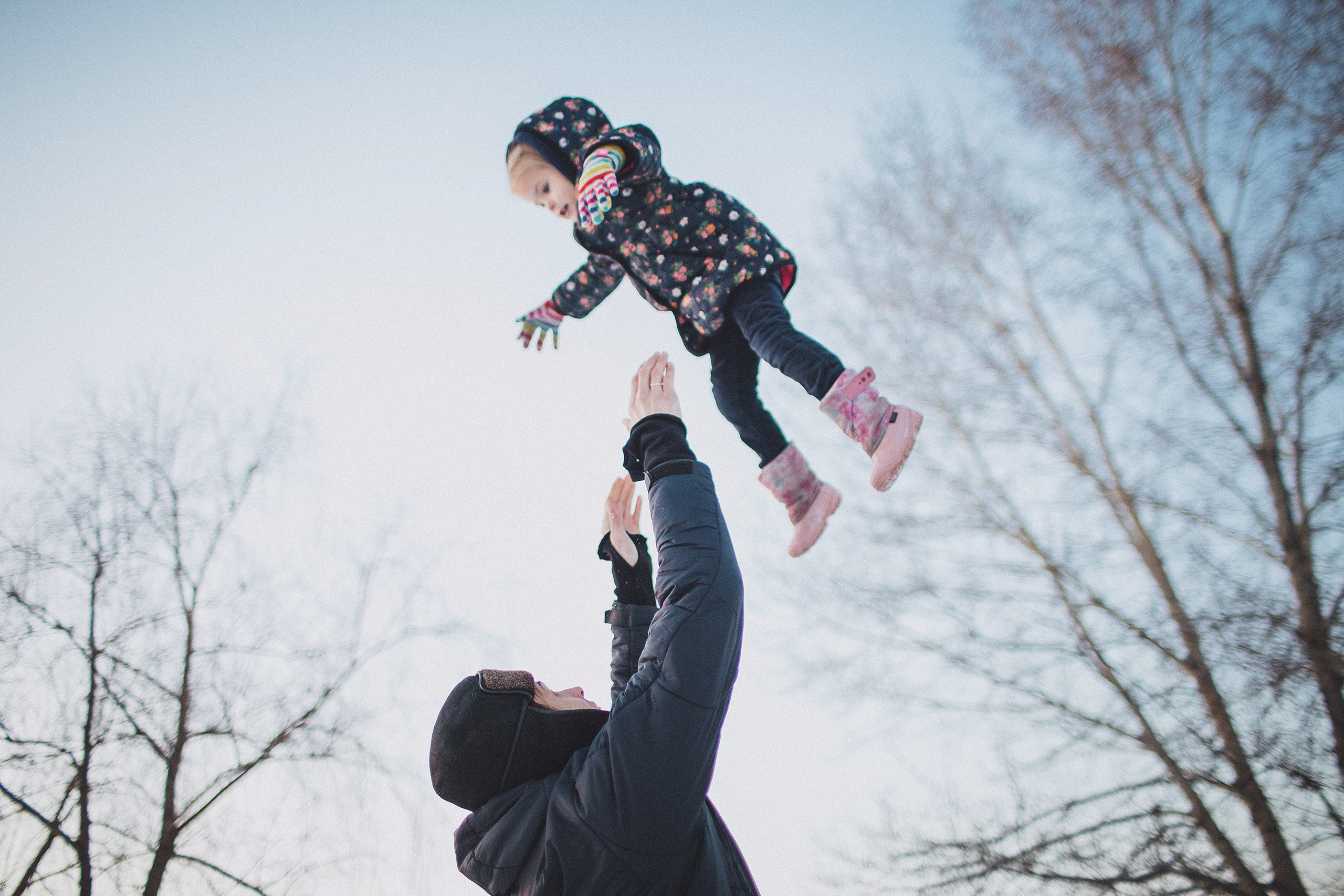 Отец подбрасывает ребёнка в воздух