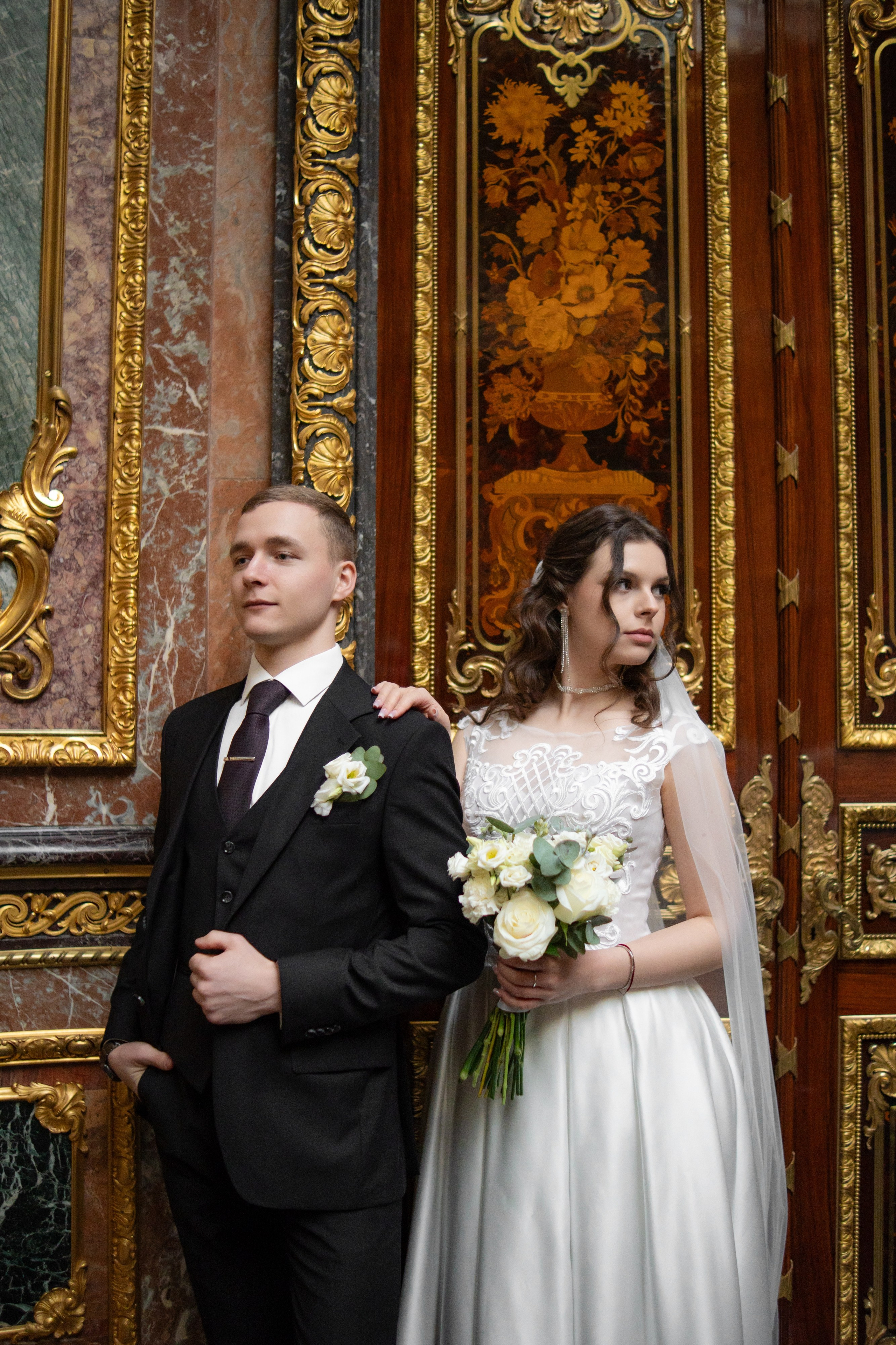 Свадебная фотосессия в Санкт-Петербурге в Особняке Половцева или Дом Архитектора. Невеста и жених стоят у красивой стены и смотрят в разные стороны