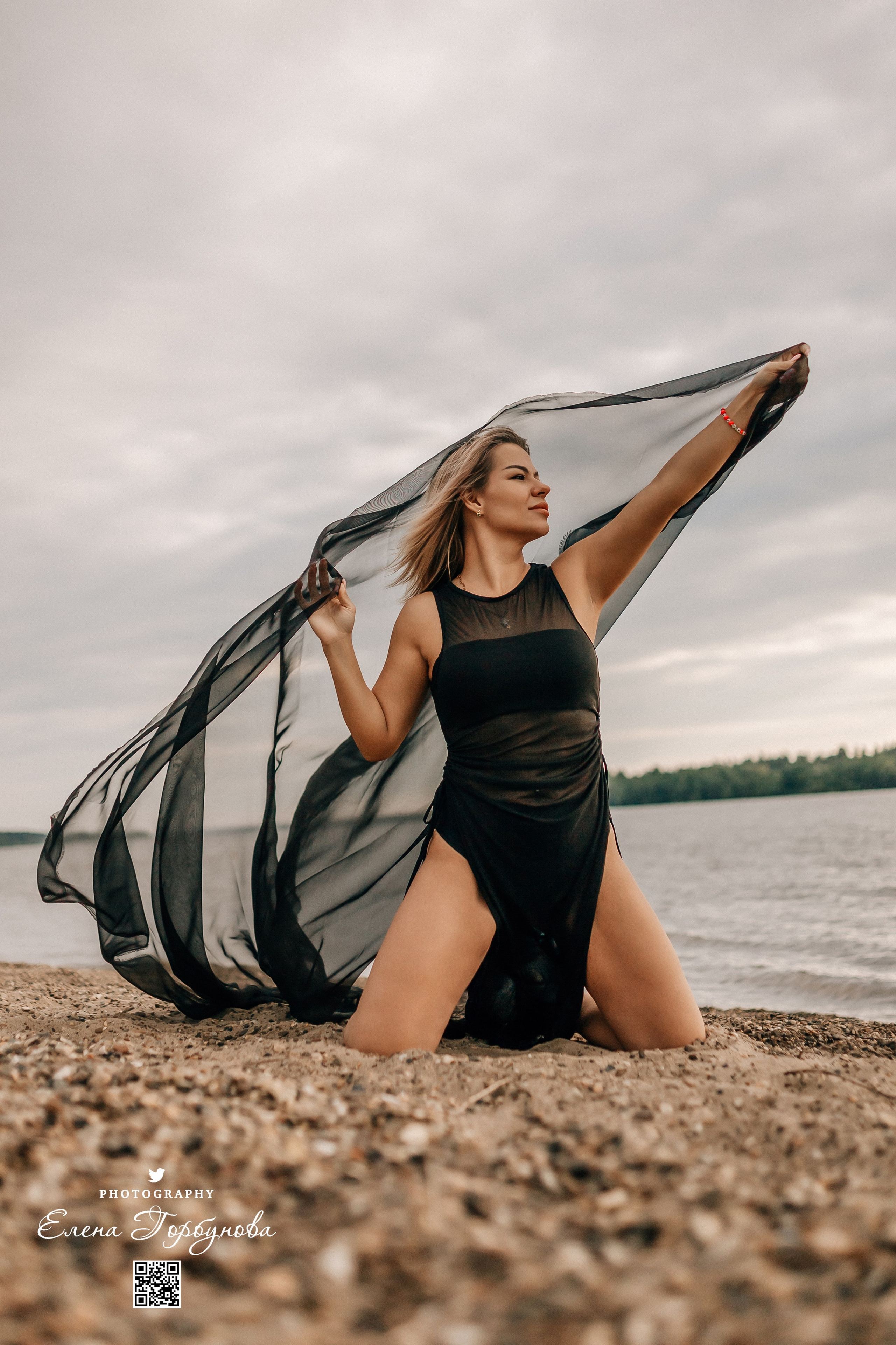 Фотосессия с черной тканью. Легкая черная вуаль летит на вертру. Фотосессия у реки черная серия с тканью. Девушка укуталась в черную ткань. Прогулка по набережной. Песок, речка, модель в черном. Качели над водой, Закат. Девушка лежит на песке. В зеленых деревьях